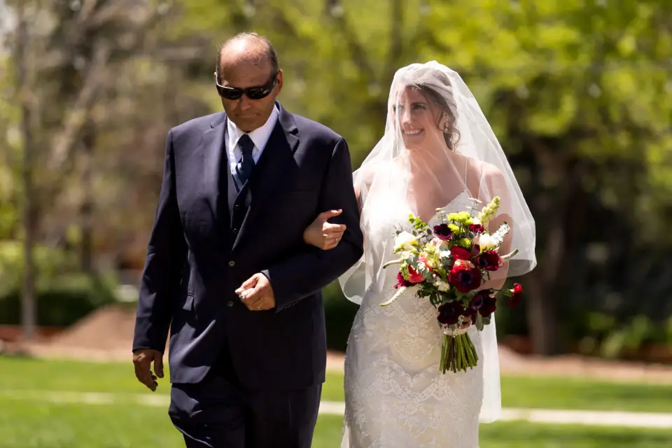 Gina and her father walk down the aisle during an Our Lady of Lourdes Denver wedding.