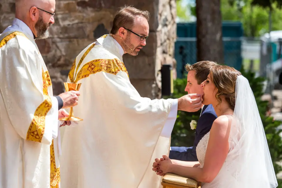 Celebrating Mass during an Our Lady of Lourdes Denver wedding.