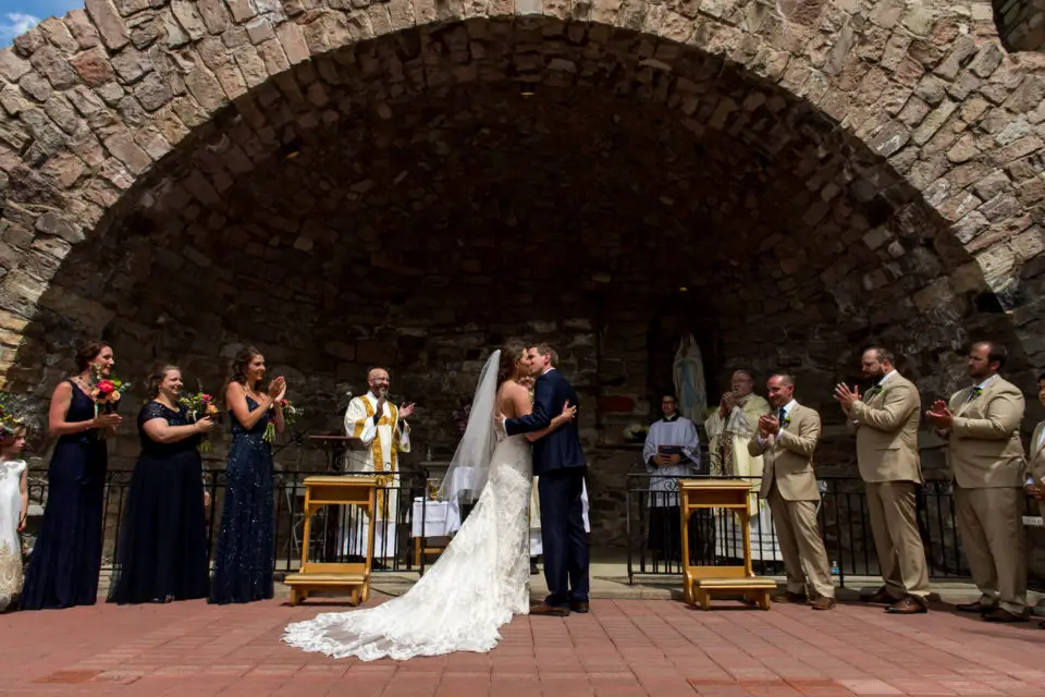 First kiss during an Our Lady of Lourdes Denver wedding.