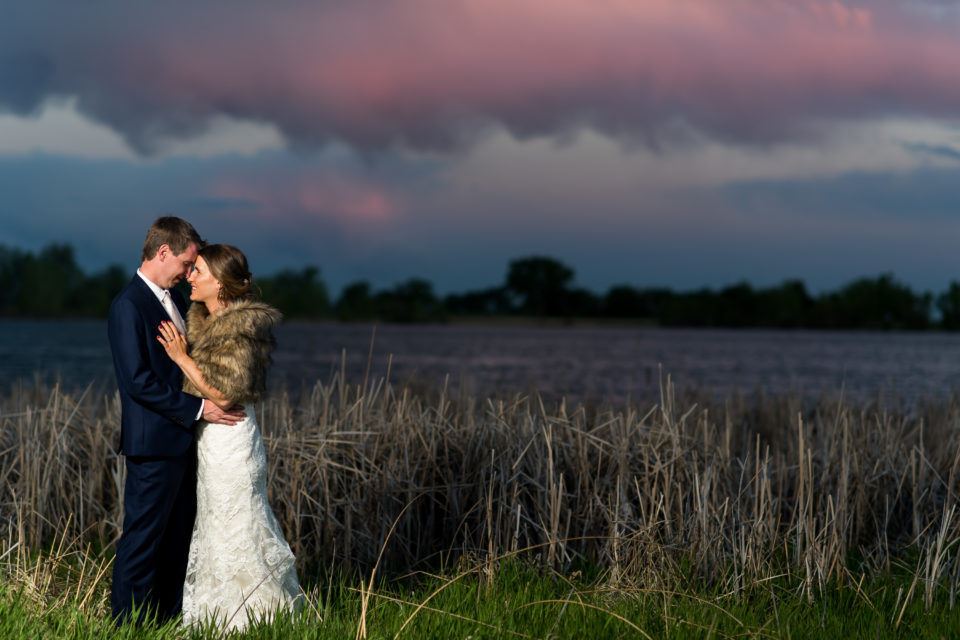 Bride and groom pose at sunset during a backyard wedding in Colorado.