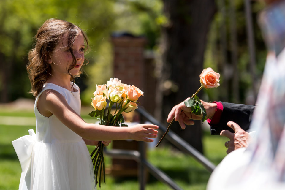 A flower girl hands out flowers during an Our Lady of Lourdes Denver wedding.