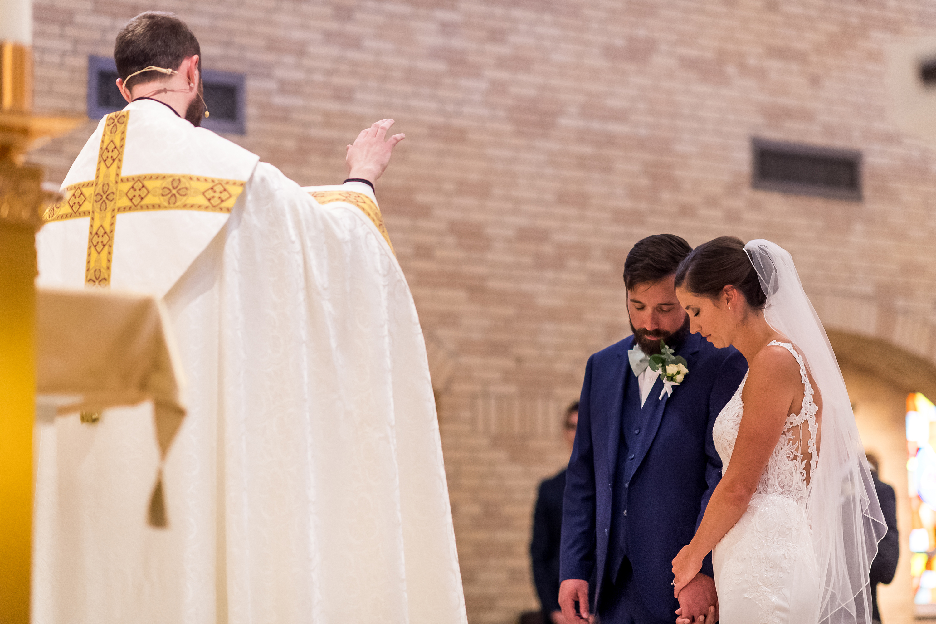Receiving a blessing during a wedding at Our Lady of Lourdes Catholic Church in Denver, Colorado