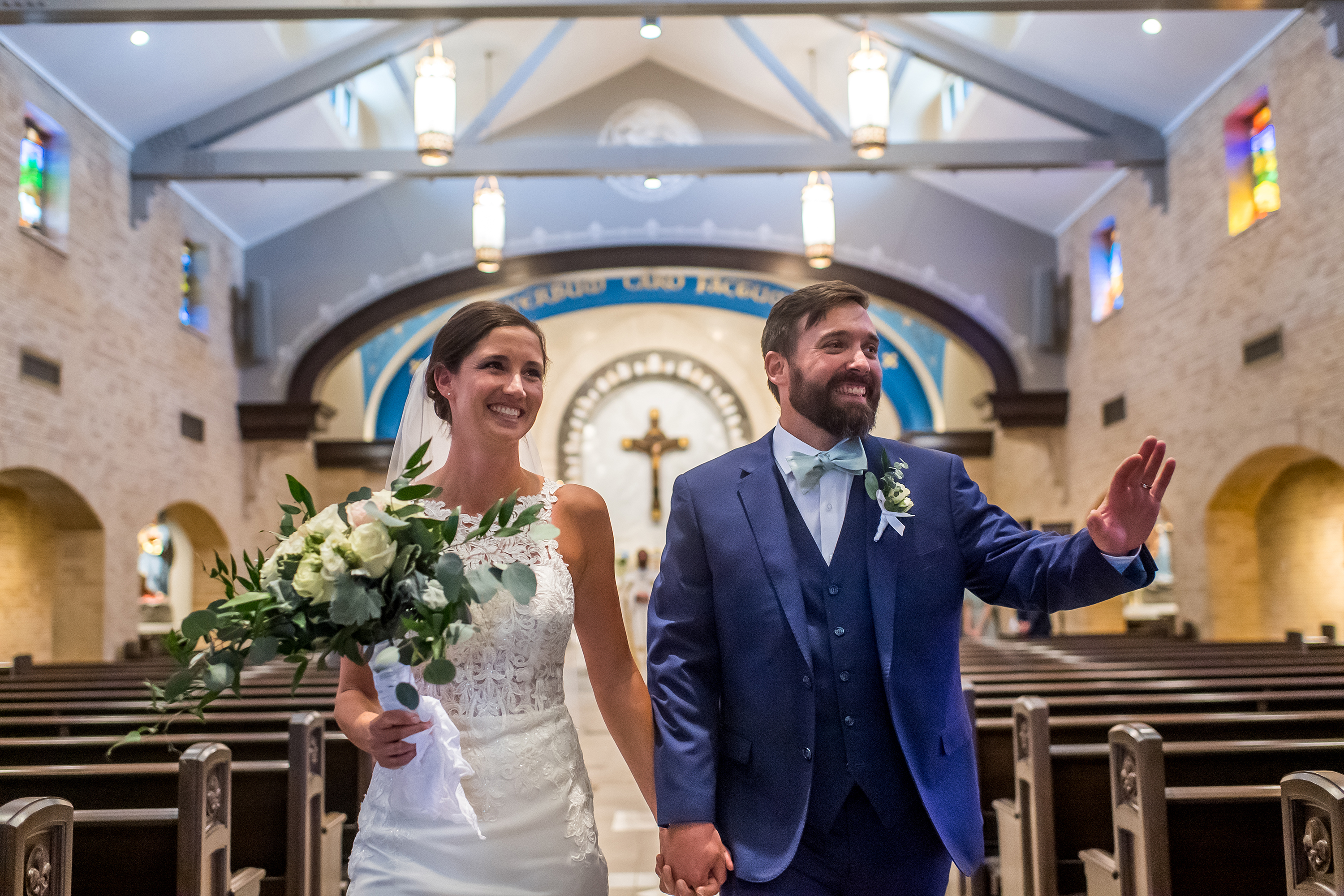 Bride and groom acknowledge friends at Our Lady of Lourdes Catholic Church in Denver, Colorado, after their wedding