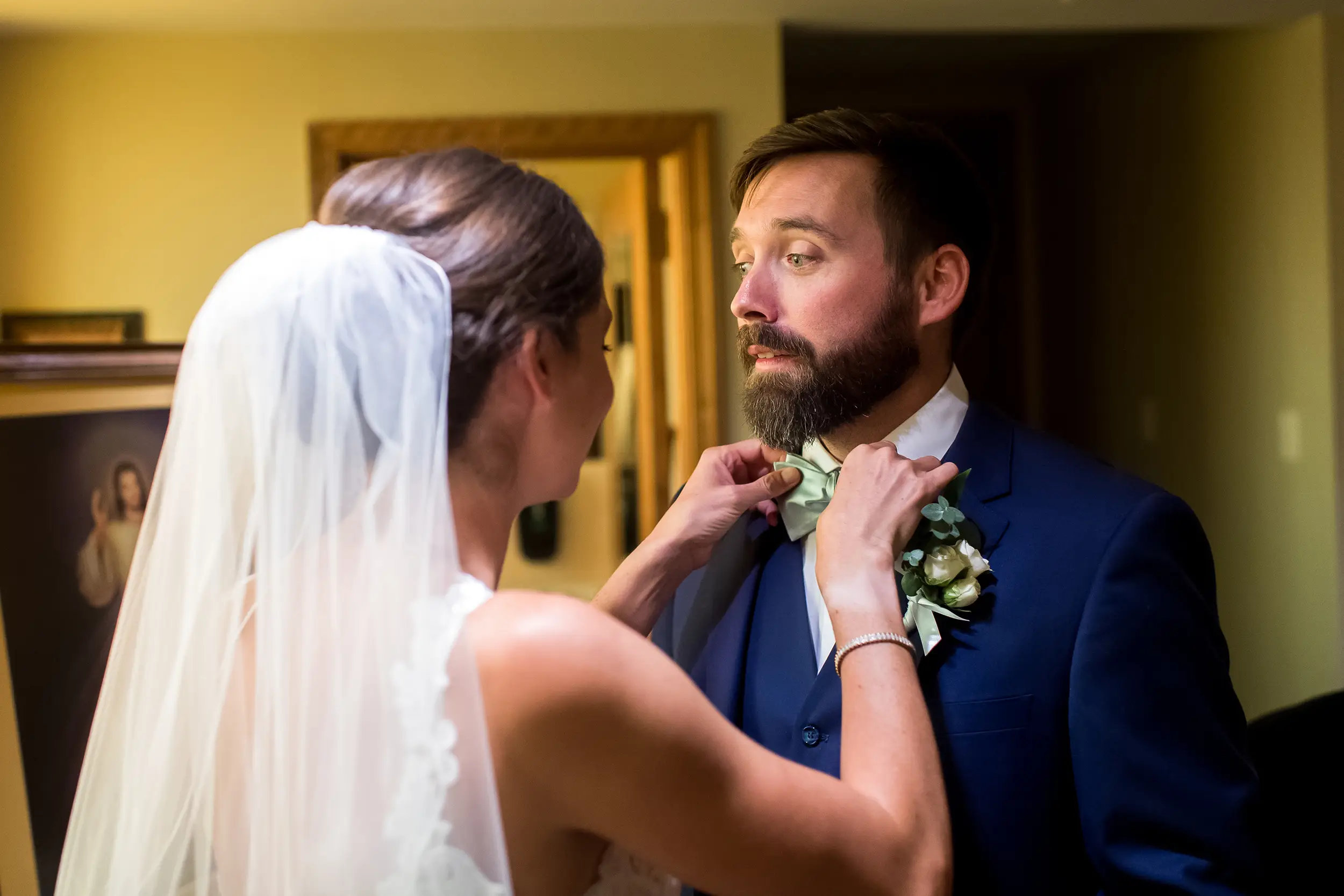 Bride adjusts groom's bow after a wedding Mass at Our Lady of Lourdes Catholic Church in Denver, Colorado.