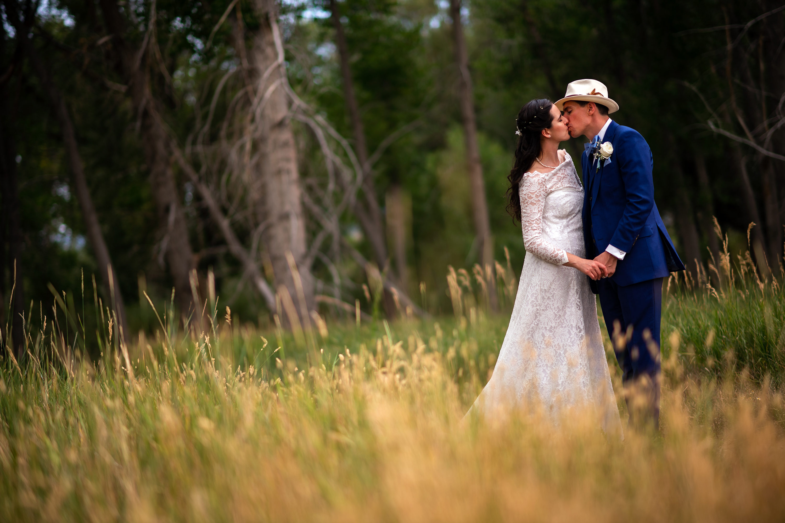 Bride and groom kiss during their wedding portrait session at Bear Creek Lake Park in Lakewood, Colorado.