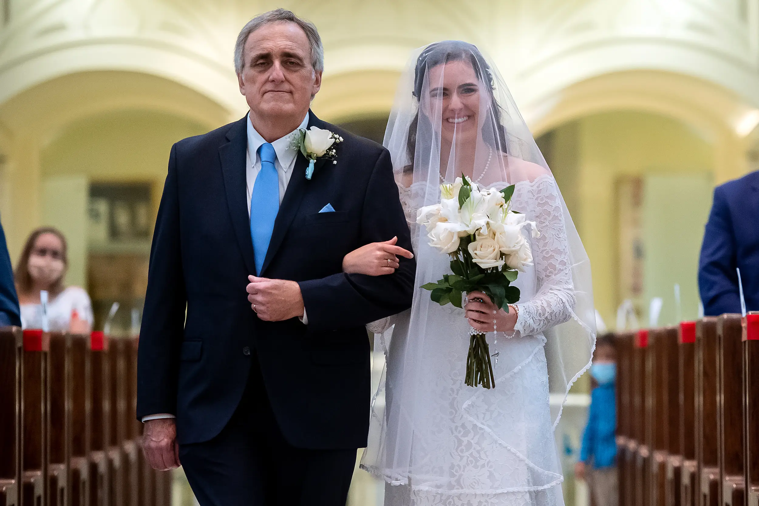 Bride and her father process in during her wedding at the Cathedral Basilica of the Immaculate Conception in Denver, Colorado.