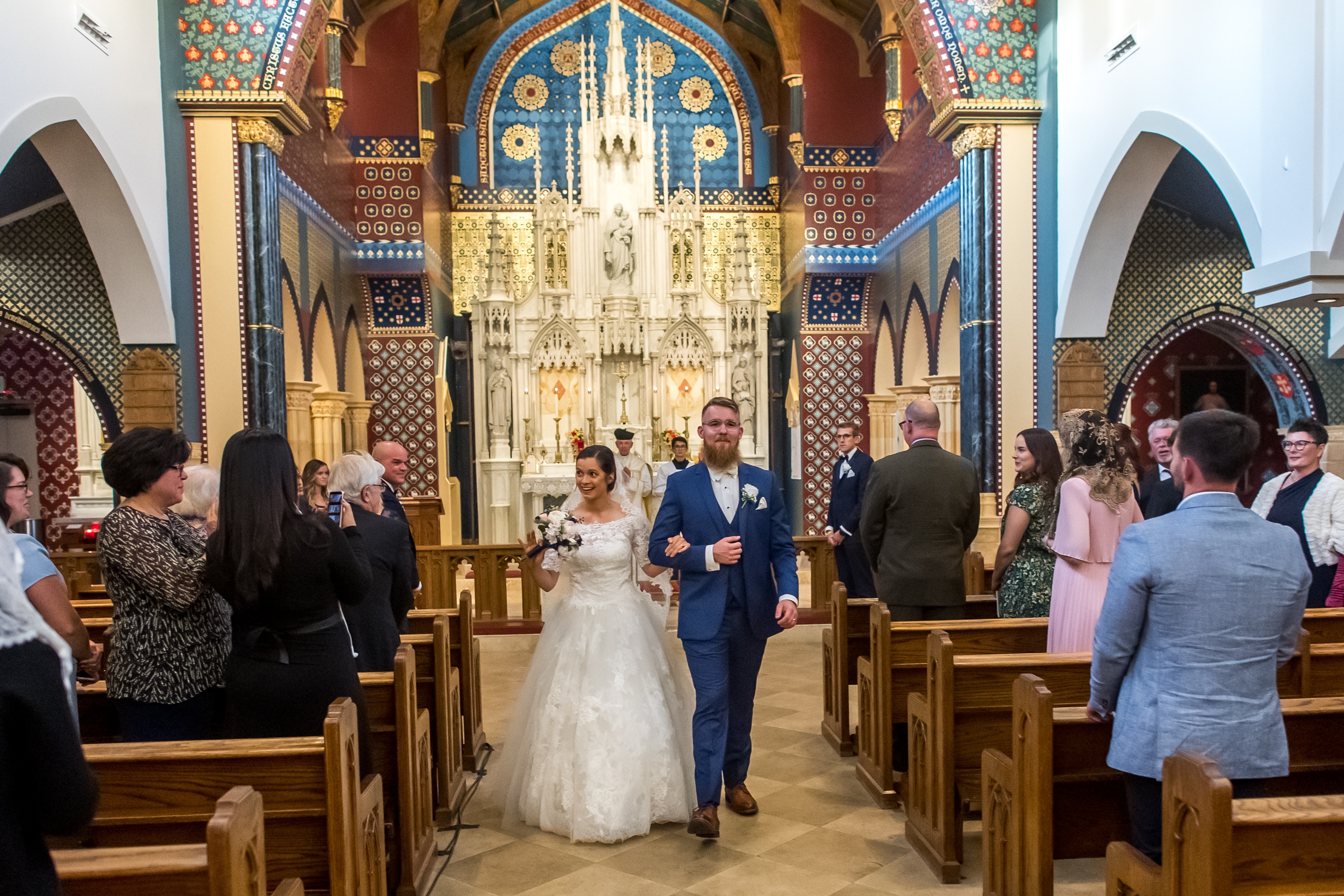Bride and groom walk down the aisle after a wedding at Our Lady of Mt. Carmel in Littleton, Colorado.