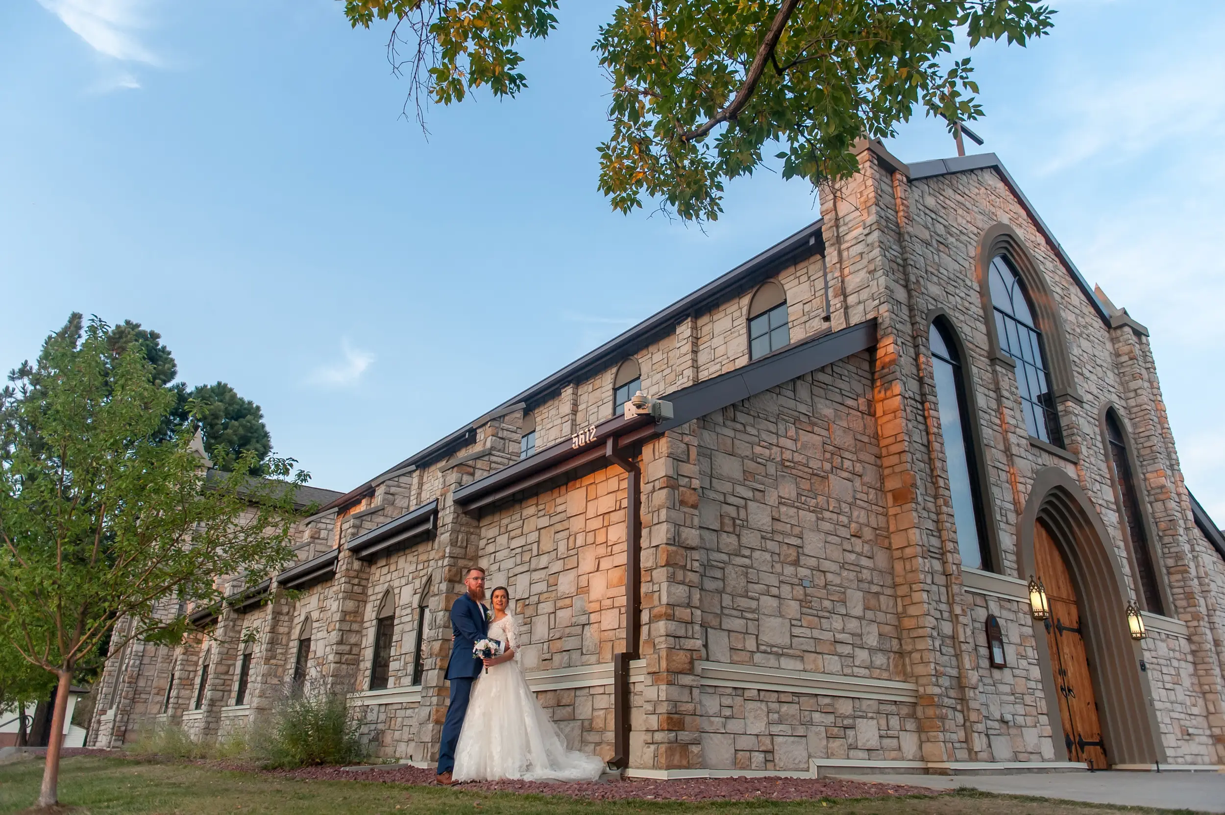 Bride and groom pose outside the church after a wedding at Our Lady of Mt. Carmel in Littleton, Colorado.