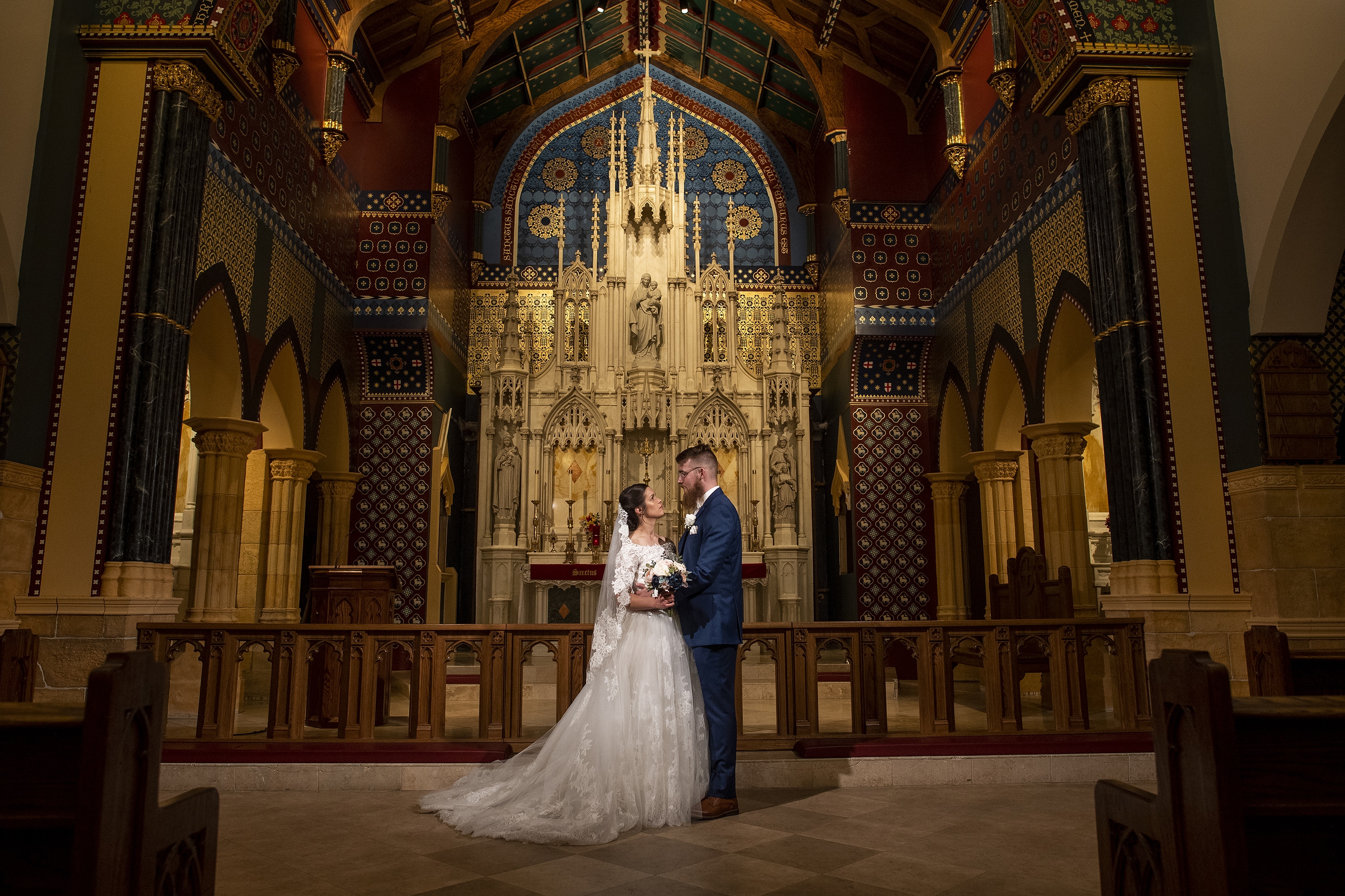 Bride and groom pose inside the church after a wedding at Our Lady of Mt. Carmel in Littleton, Colorado.