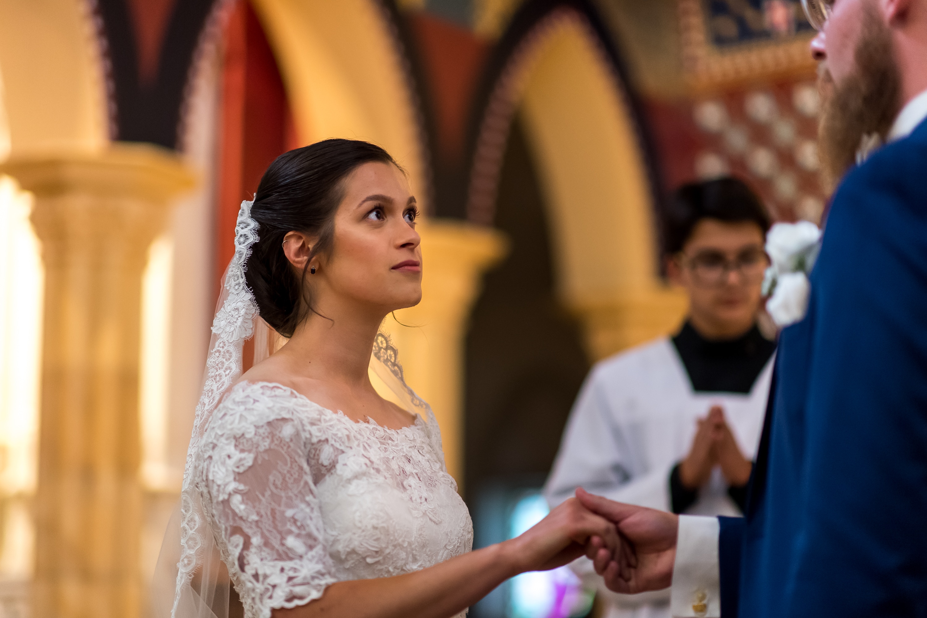 Bride looks on during her wedding at Our Lady of Mt. Carmel in Littleton, Colorado.