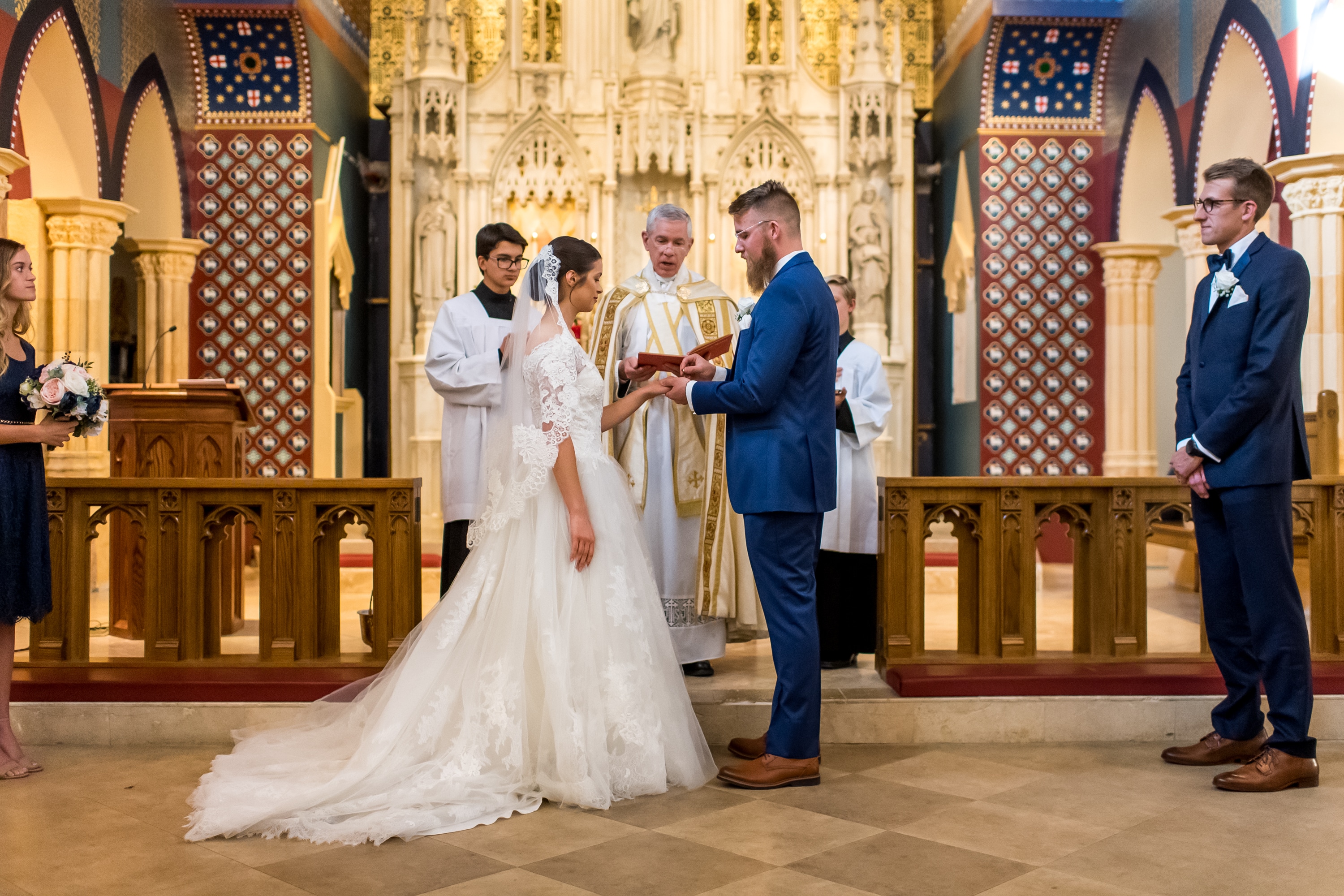 Groom puts on the ring at Our Lady of Mt. Carmel in Littleton, Colorado.