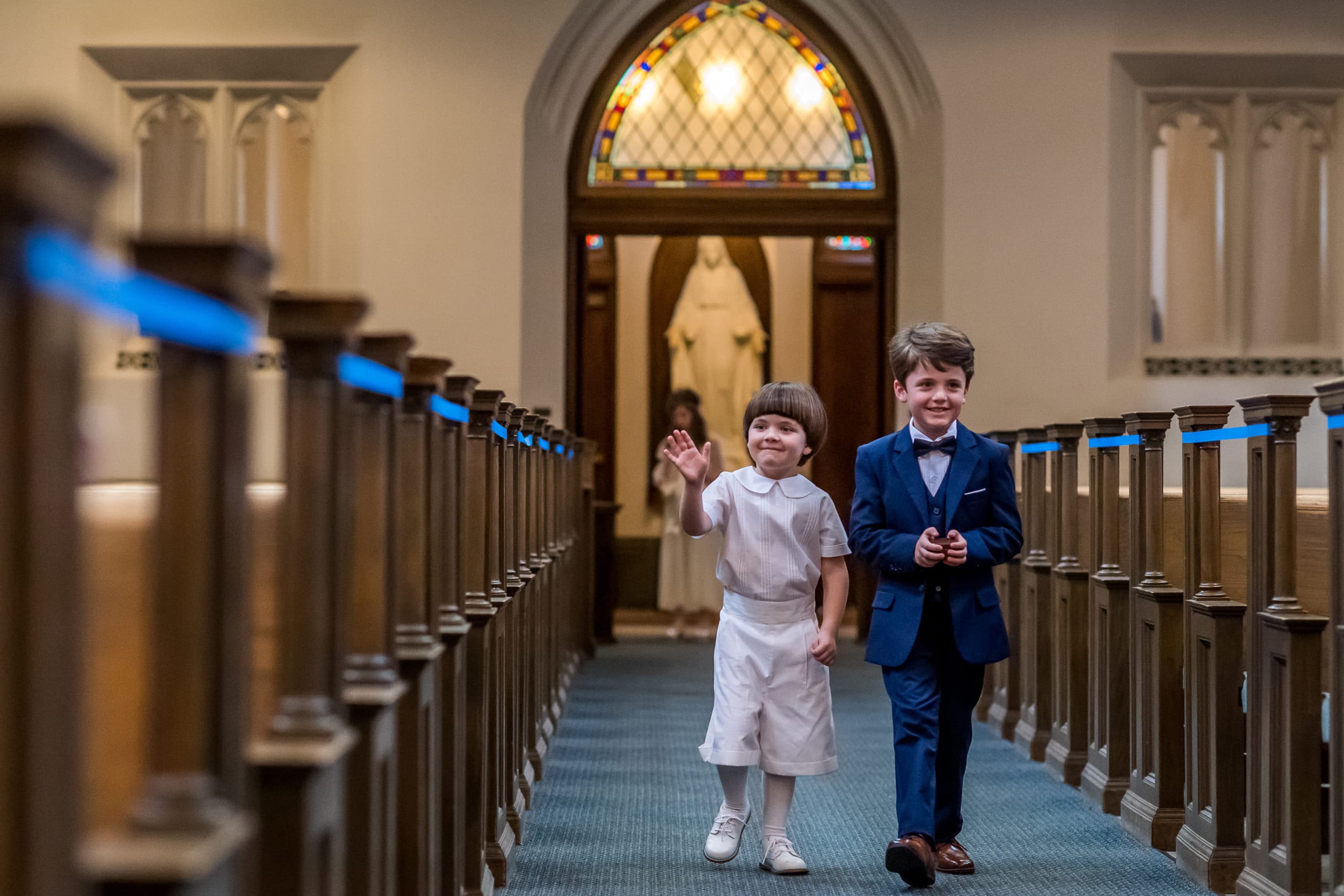 Ring bearers come in during a Blessed Sacrament Denver wedding in Colorado.