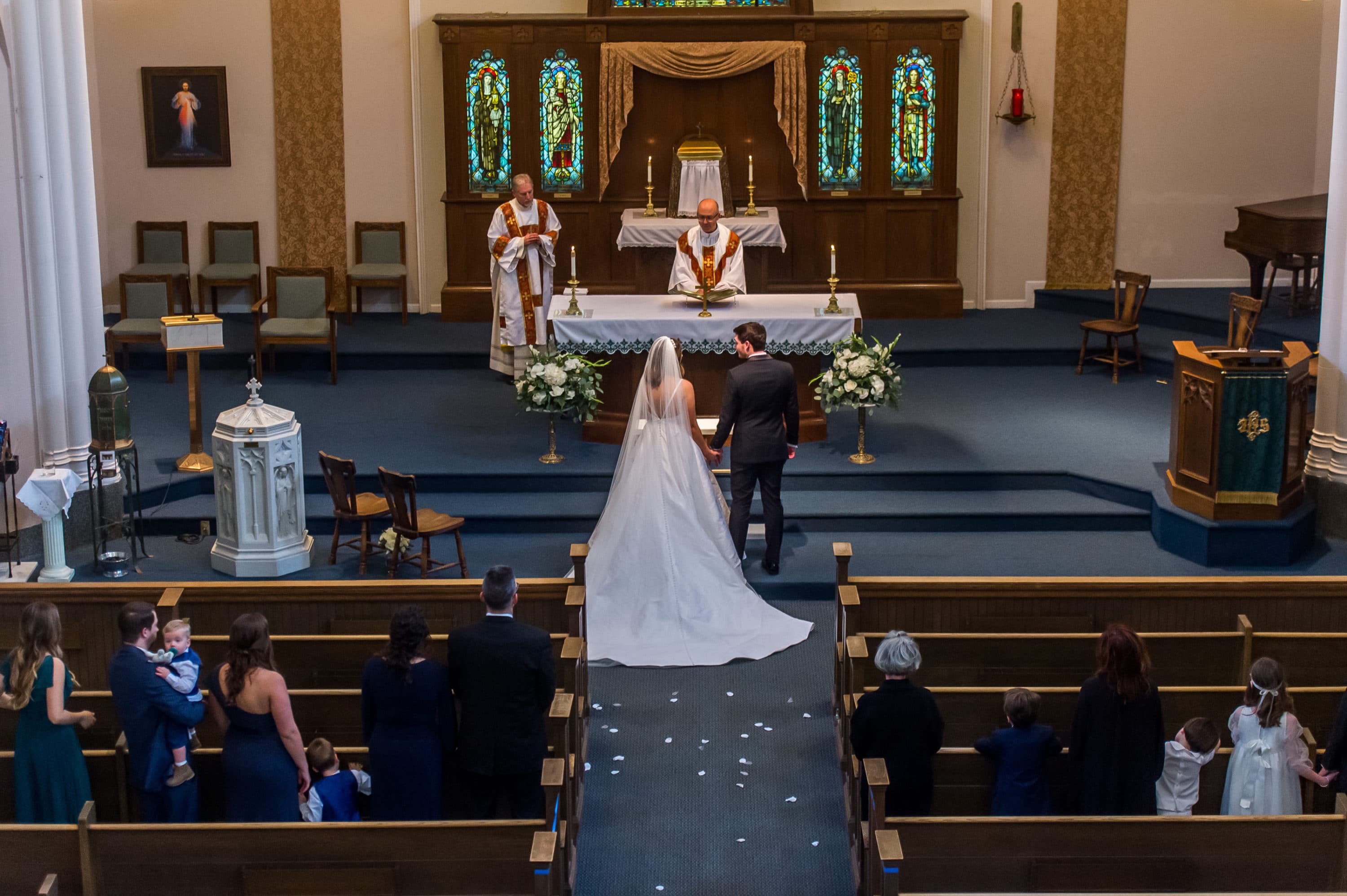 Bride and groom stand before the altar during a Blessed Sacrament Denver wedding.