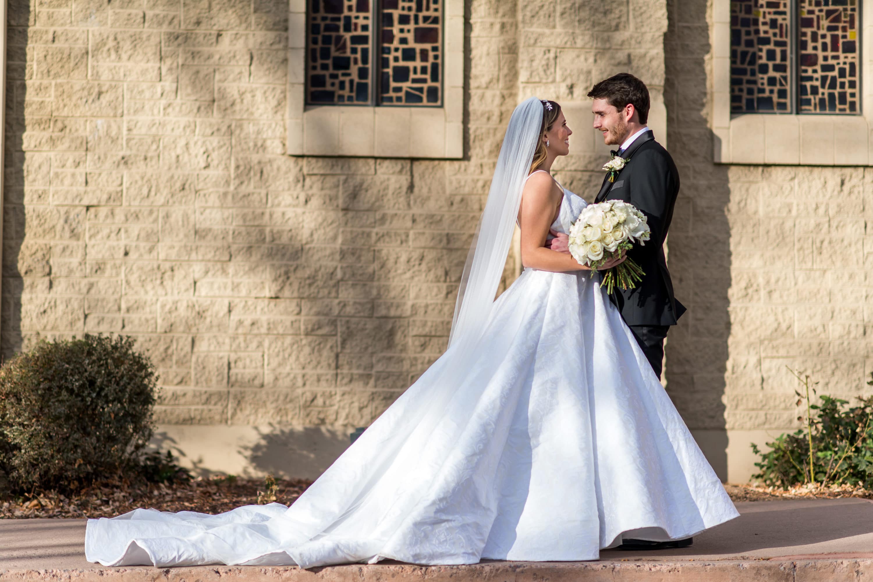 Bride and Groom pose outside Blessed Sacrament Denver Church after a wedding.