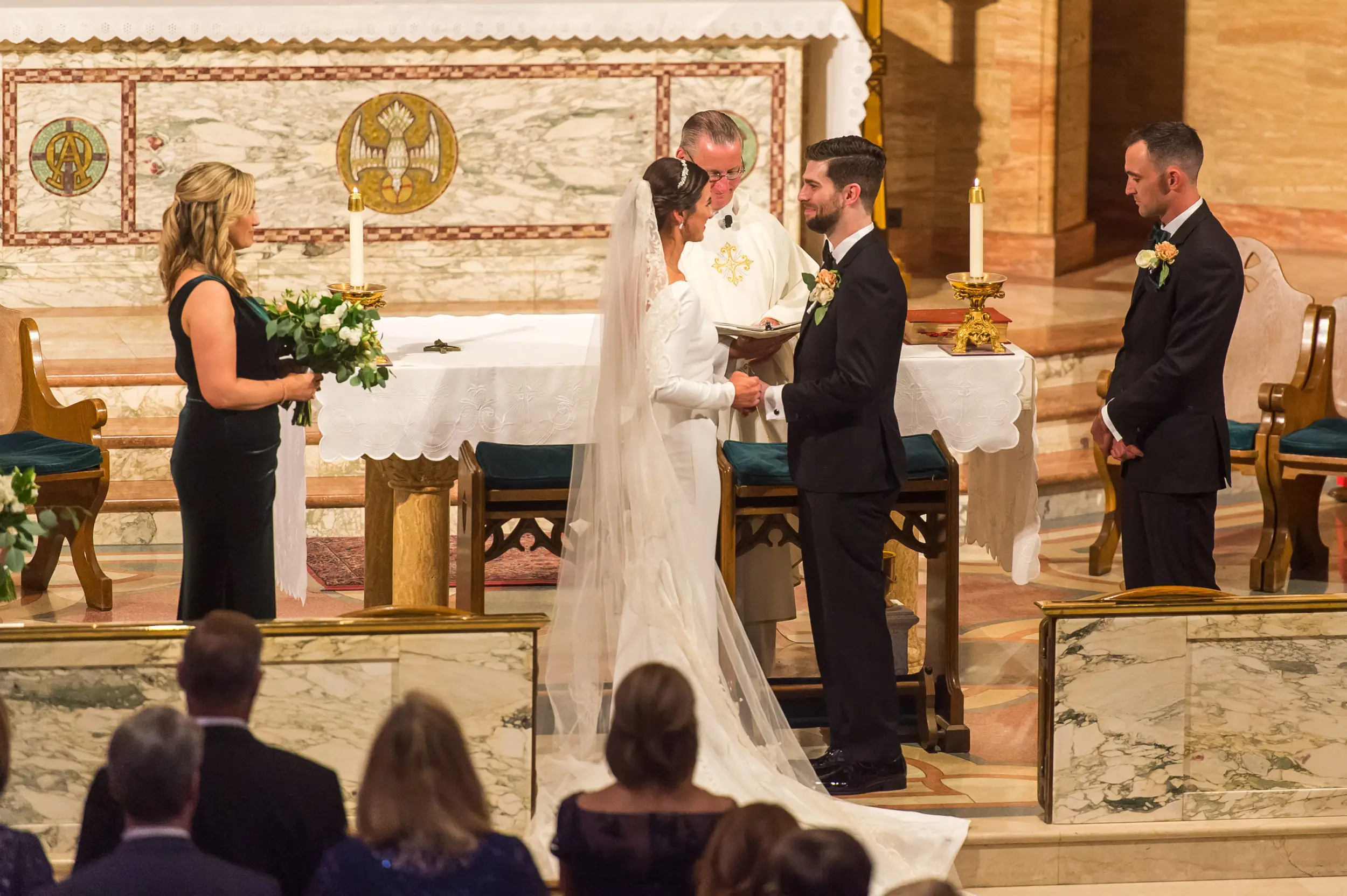 Bride and groom look on during their Holy Ghost Church Denver wedding Mass in Denver, Colorado.