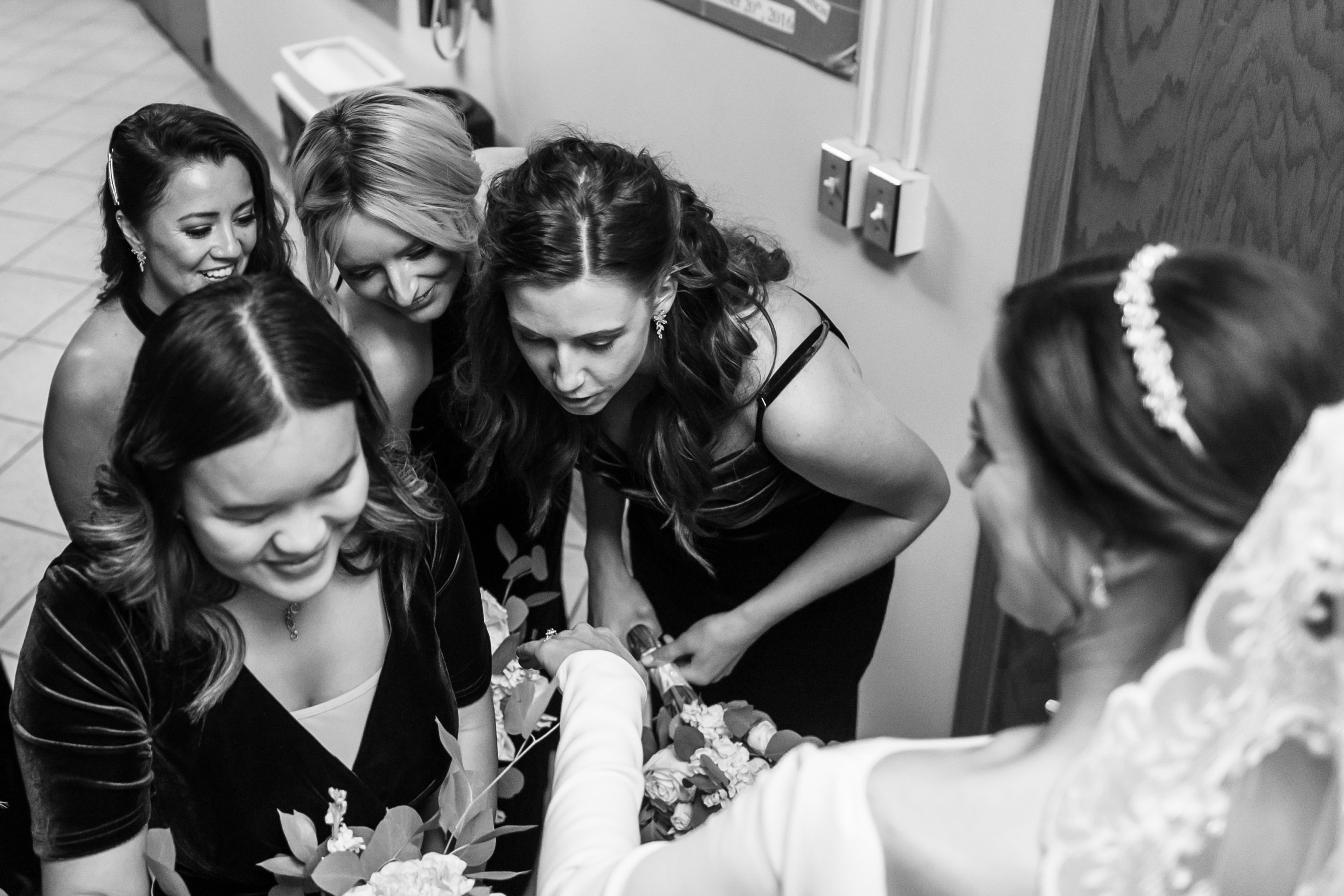Bride shows ring to bridesmaids after Holy Ghost Church Denver wedding Mass in Denver, Colorado.