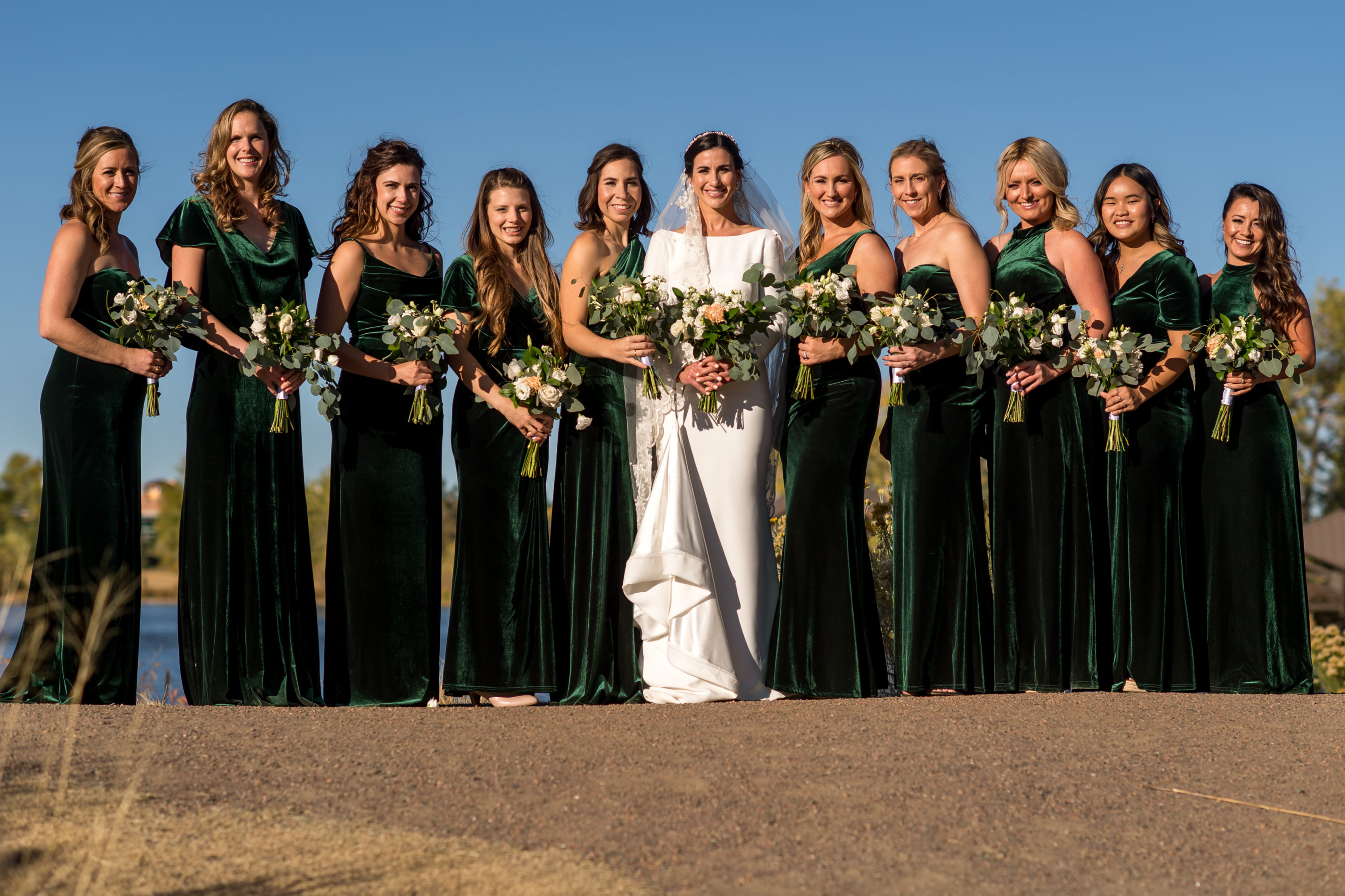 Bride and bridesmaids pose during wedding photo portraits at Belmar Park in Lakewood, Colorado.
