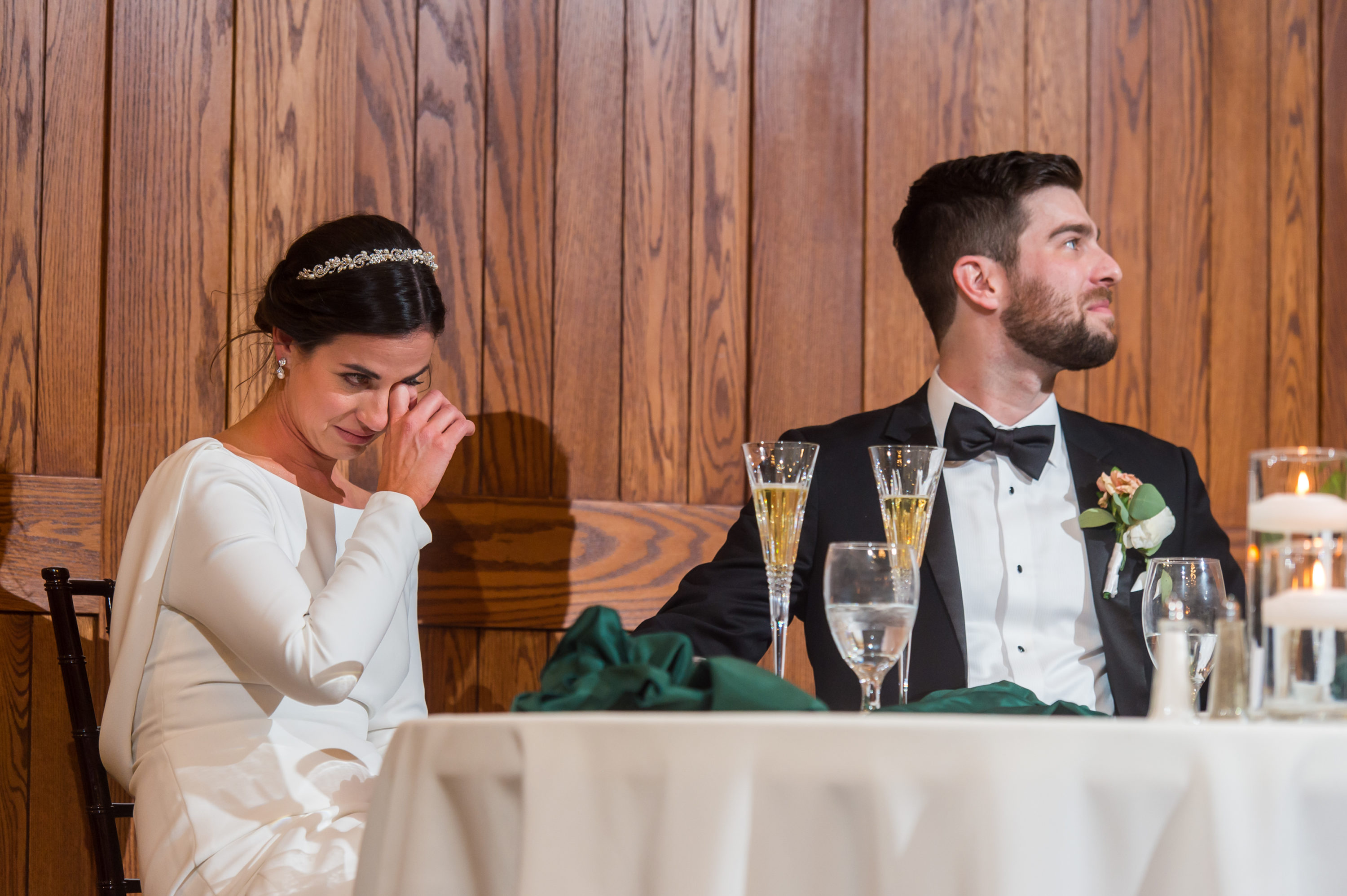 Bride and groom look on during toasts at Baldoria on the Water wedding venue in Lakewood, Colorado.