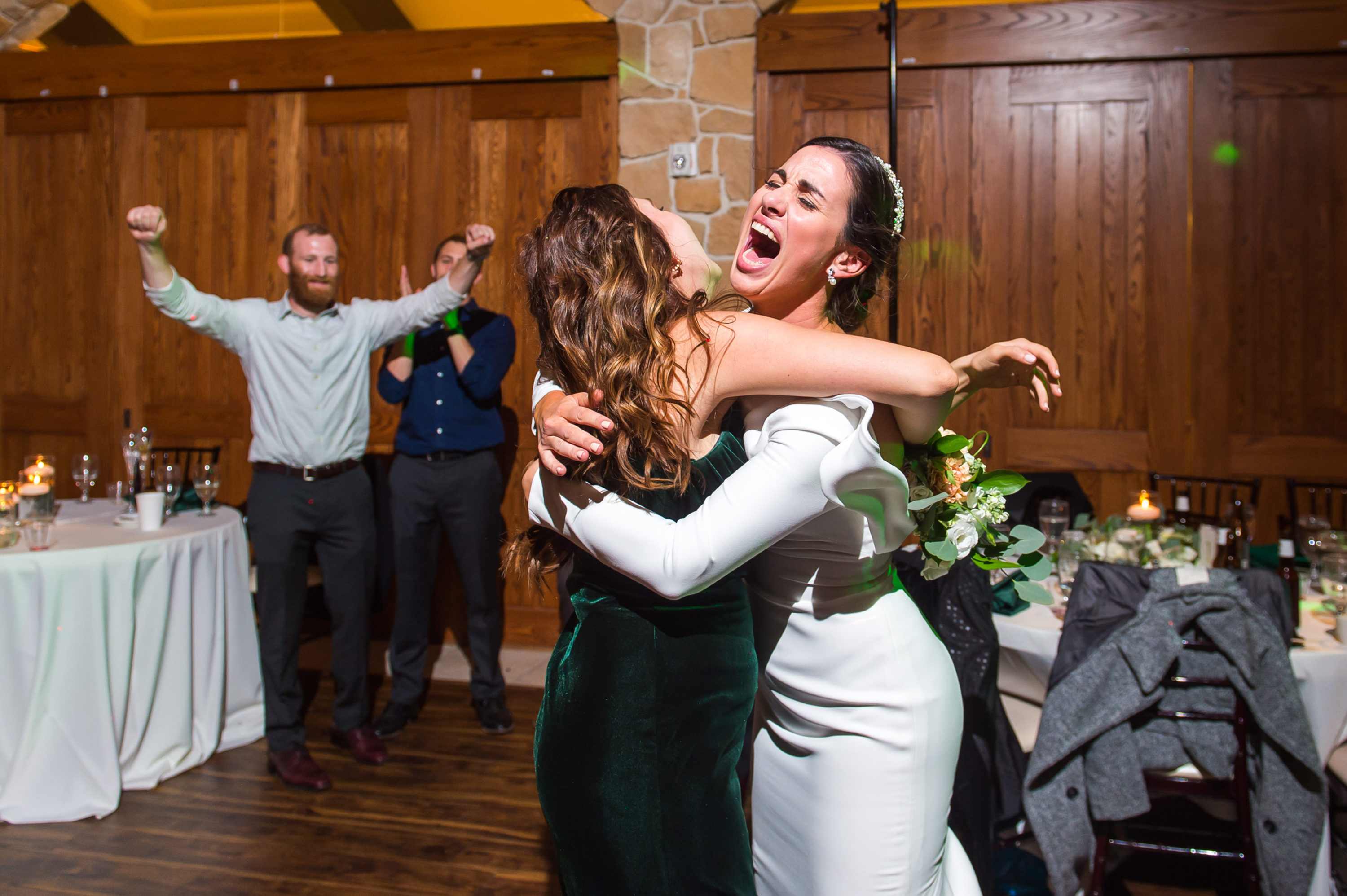 Bride reacts with bridesmaid at Baldoria on the Water wedding venue in Lakewood, Colorado.