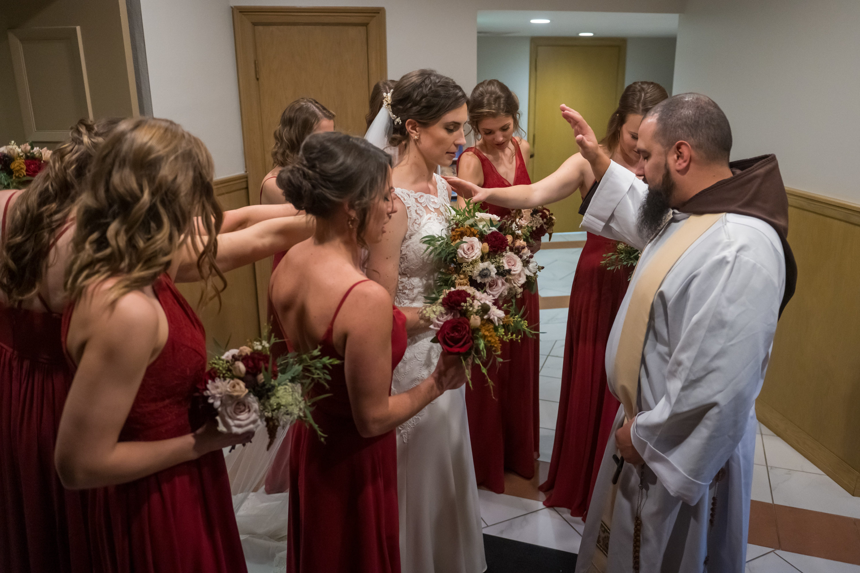 The priest prays over the bride before her Cathedral Basilica of the Immaculate Conception wedding in Denver, Colorado.