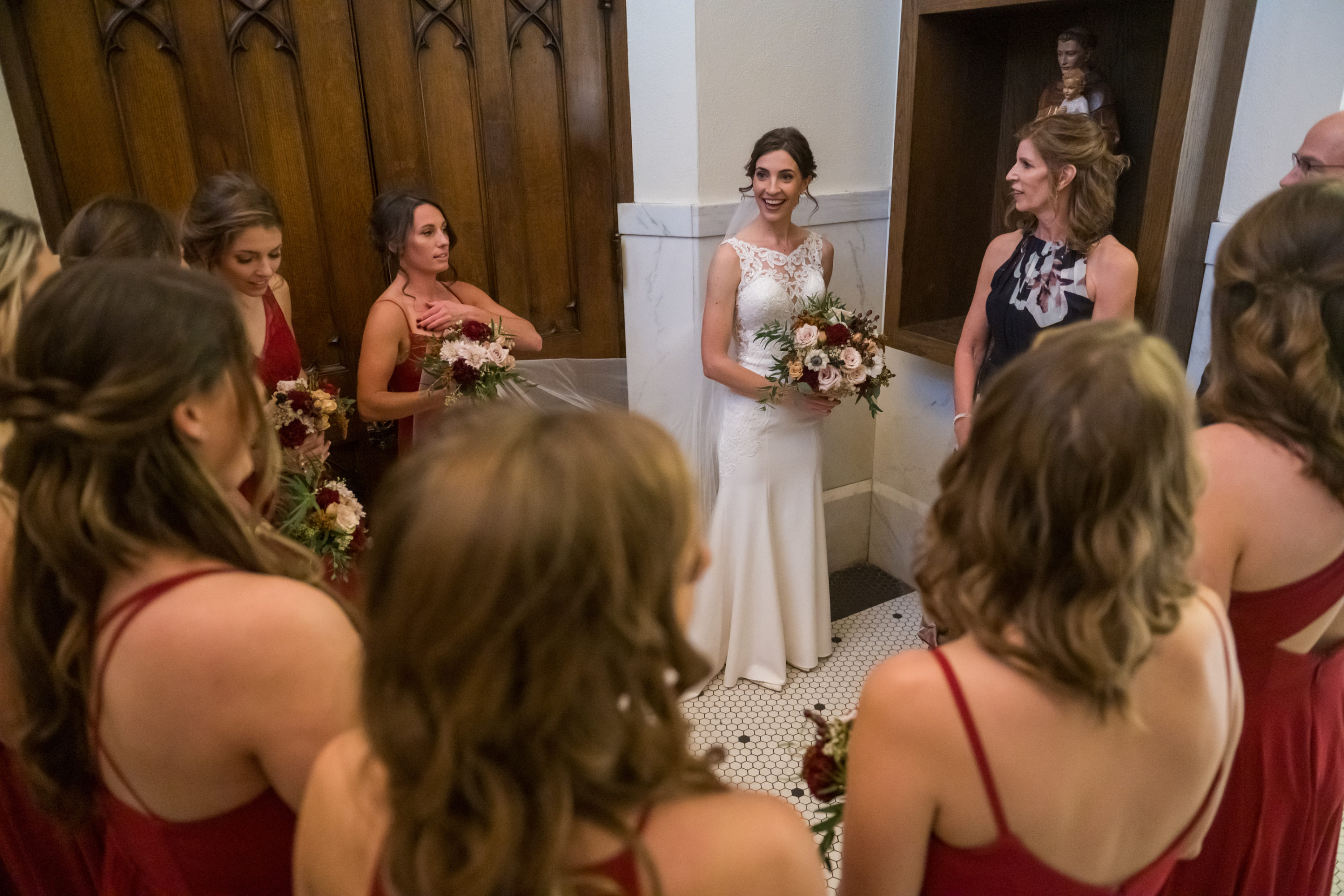 The bride looks to her bridesmaids before processing in during her Cathedral Basilica of the Immaculate Conception wedding in Denver, Colorado.
