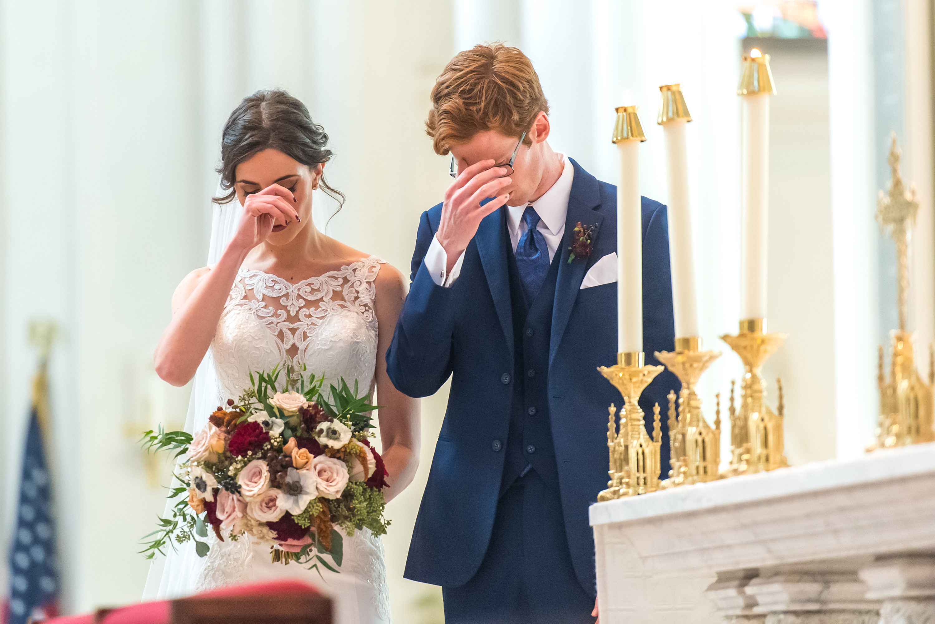 The bride and groom cross themselves during a Cathedral Basilica of the Immaculate Conception wedding in Denver, Colorado.