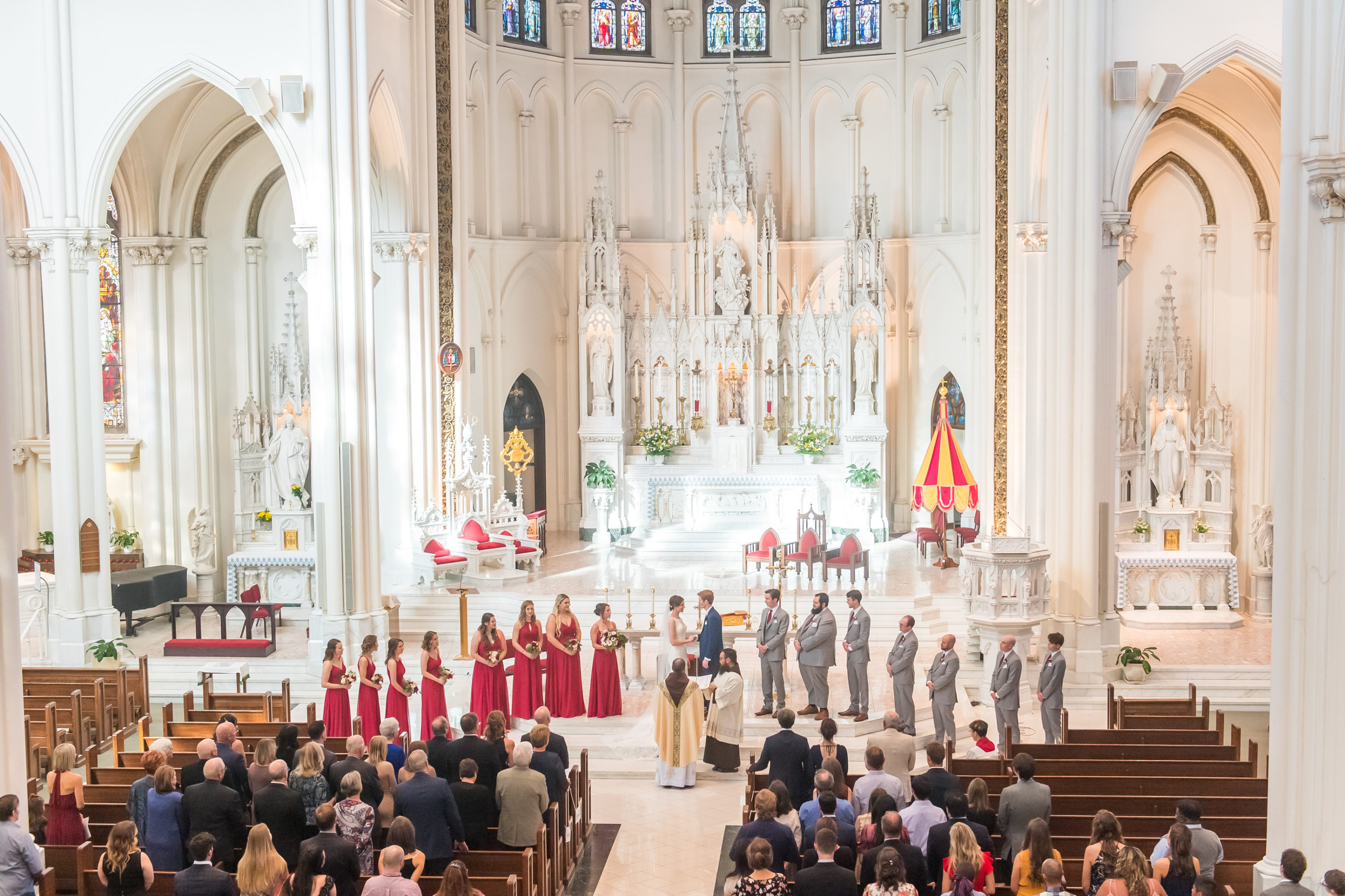 The bride and groom hold hands during a Cathedral Basilica of the Immaculate Conception wedding in Denver, Colorado.