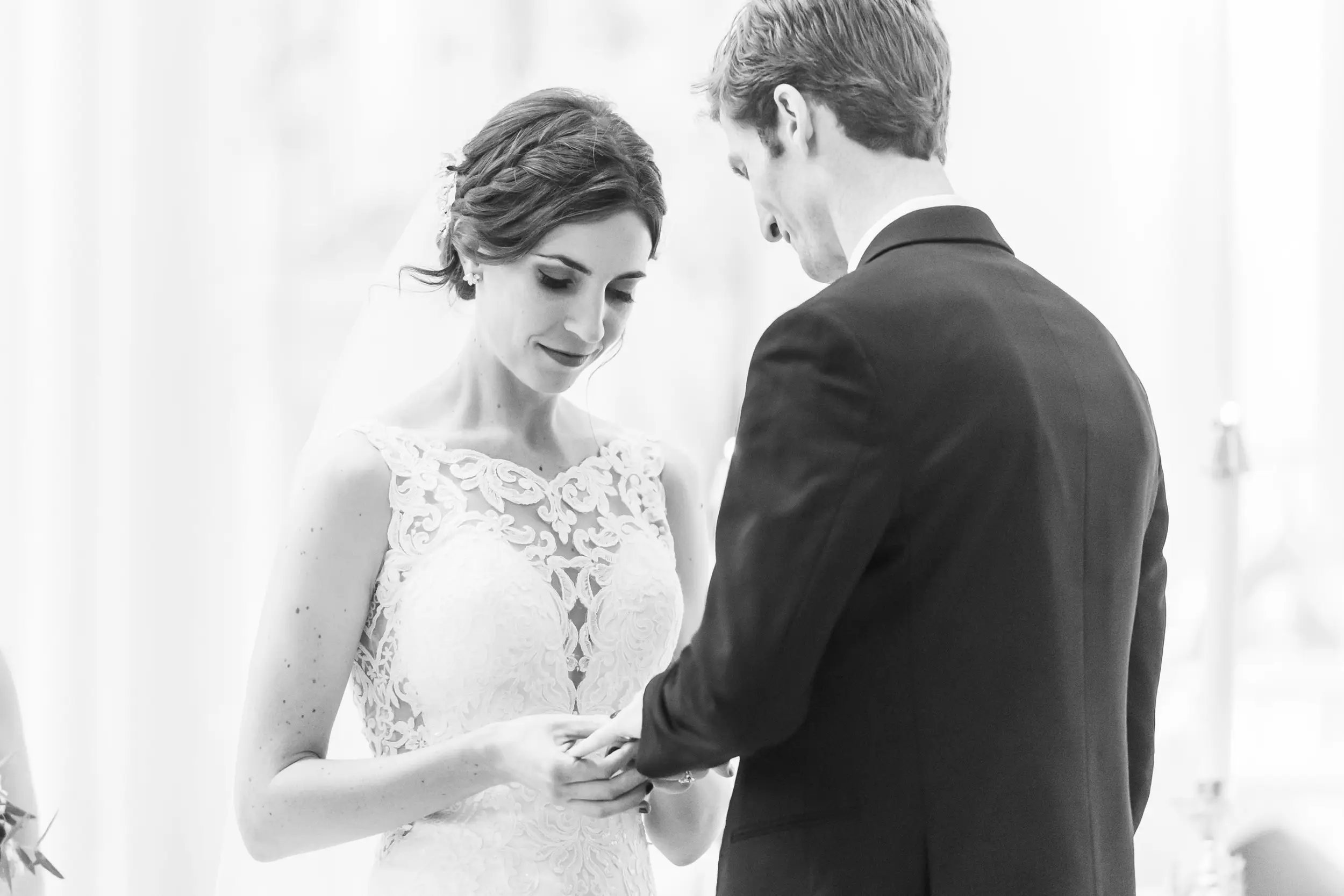 The bride puts the ring on the groom's finger during a Cathedral Basilica of the Immaculate Conception wedding in Denver, Colorado.