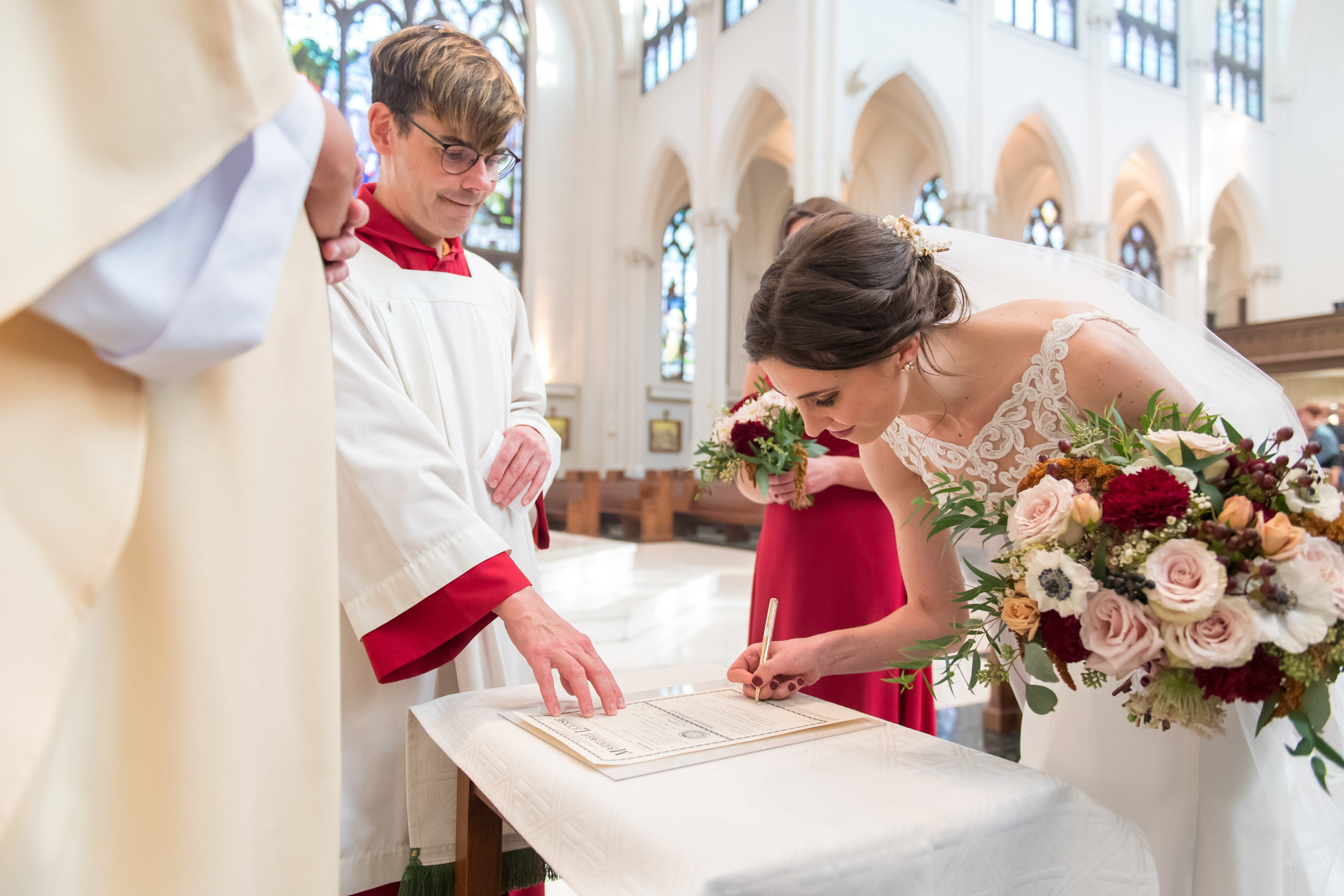Bride signs the marriage license during a Cathedral Basilica of the Immaculate Conception wedding in Denver, Colorado.