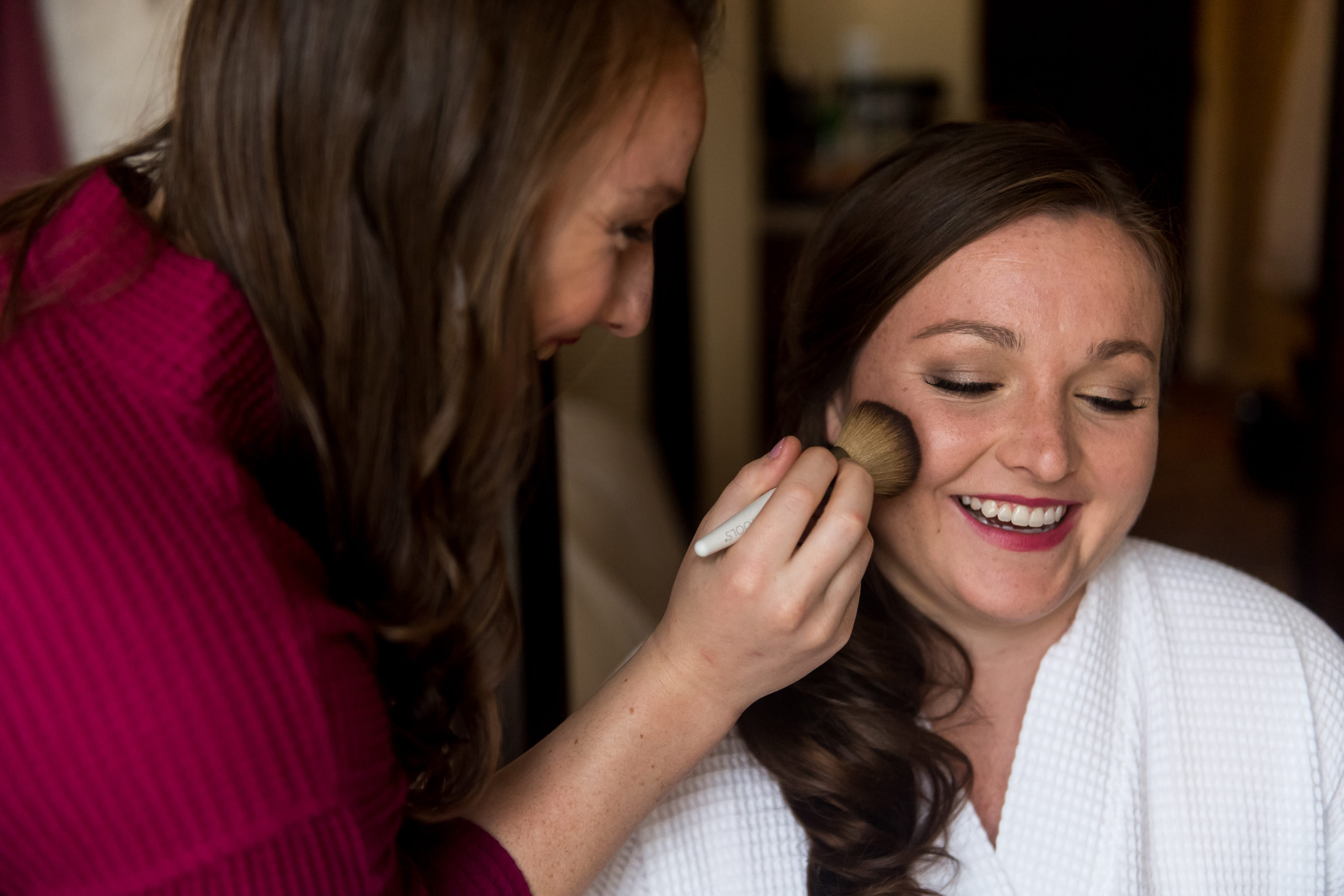 The bride gets makeup done before a Greenbriar Inn wedding in Boulder, Colorado.