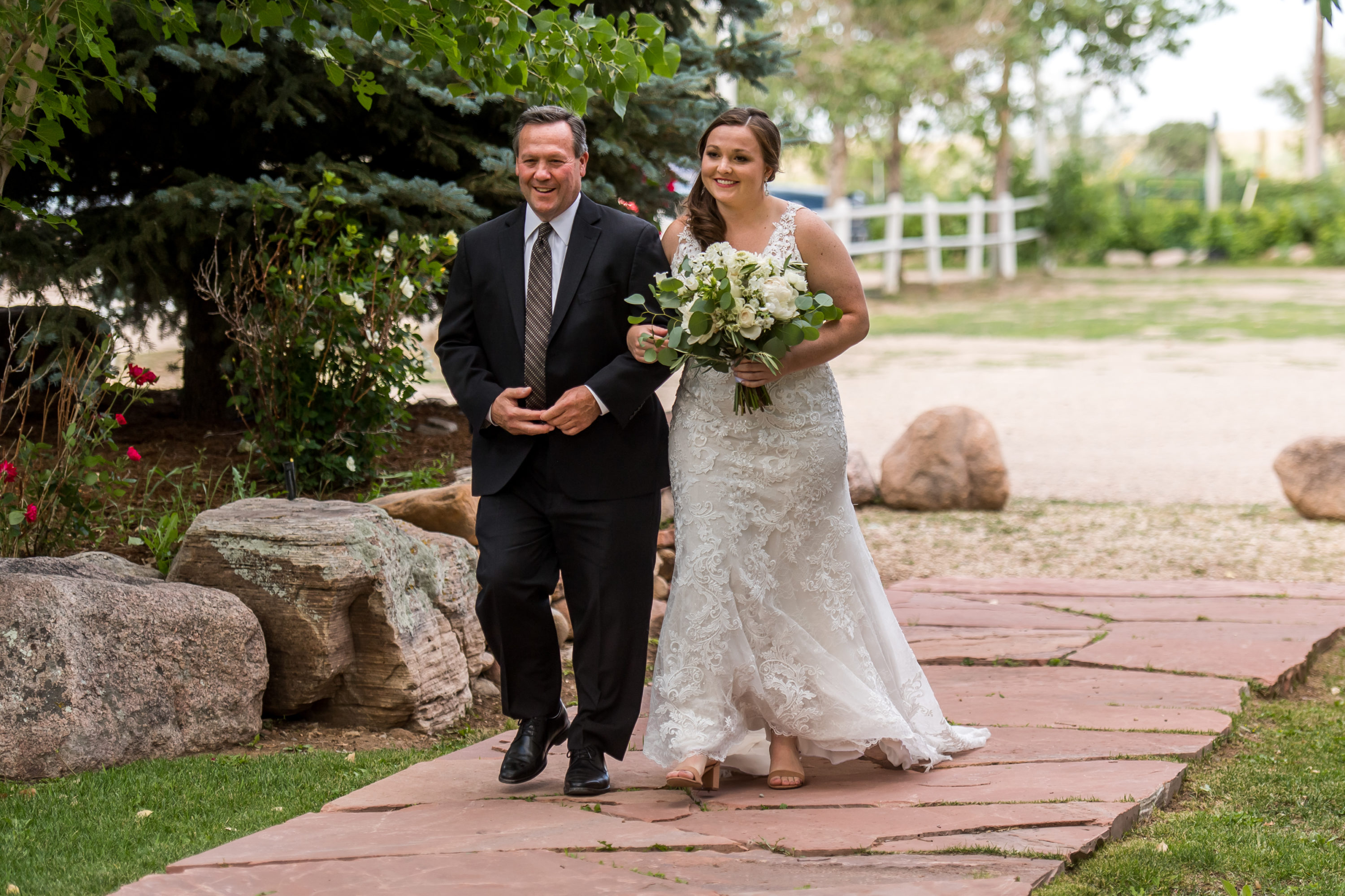 The bride walks down the aisle with her father during a Greenbriar Inn wedding in Boulder, Colorado.