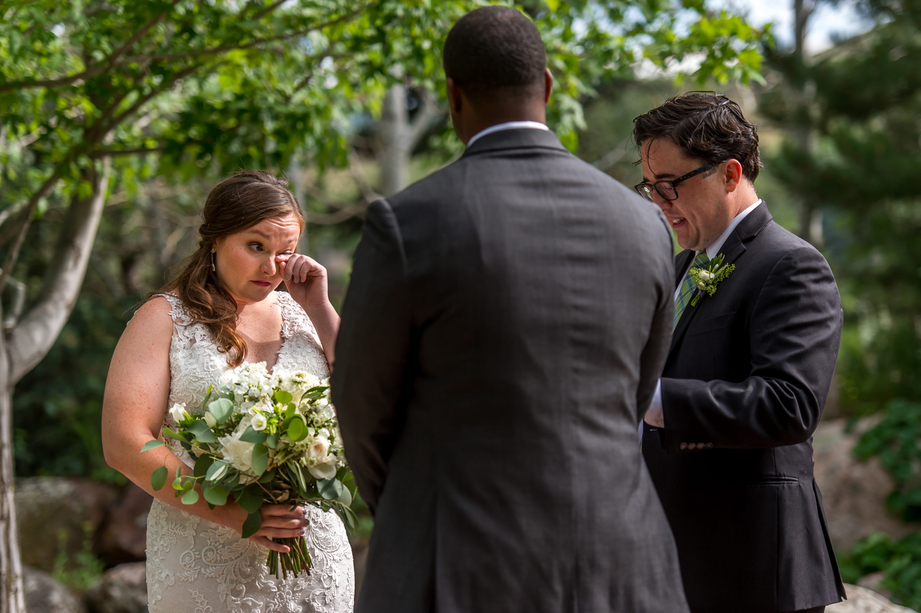 The bride wipes away a tear during a Greenbriar Inn wedding in Boulder, Colorado.