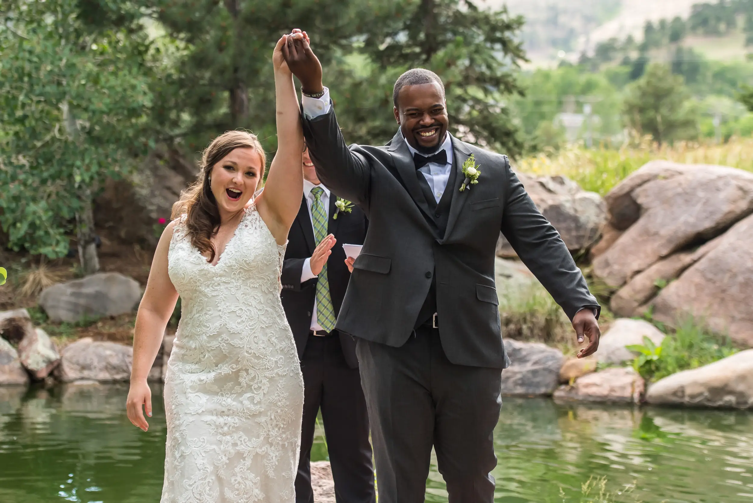The bride and groom raise their hands after being married during a Greenbriar Inn wedding in Boulder, Colorado.