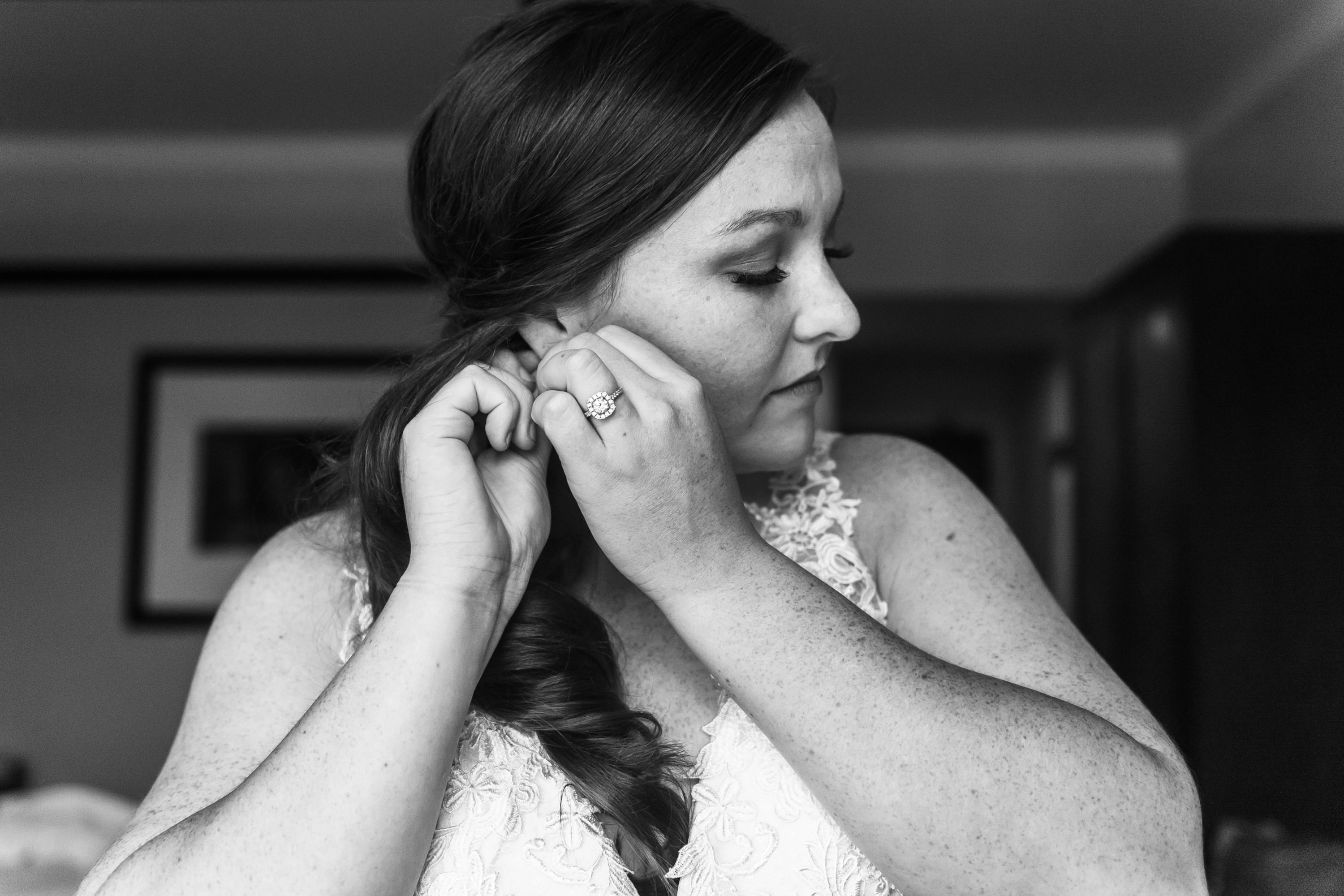 The bride puts on earrings before her wedding at the Greenbriar Inn in Boulder, Colorado.