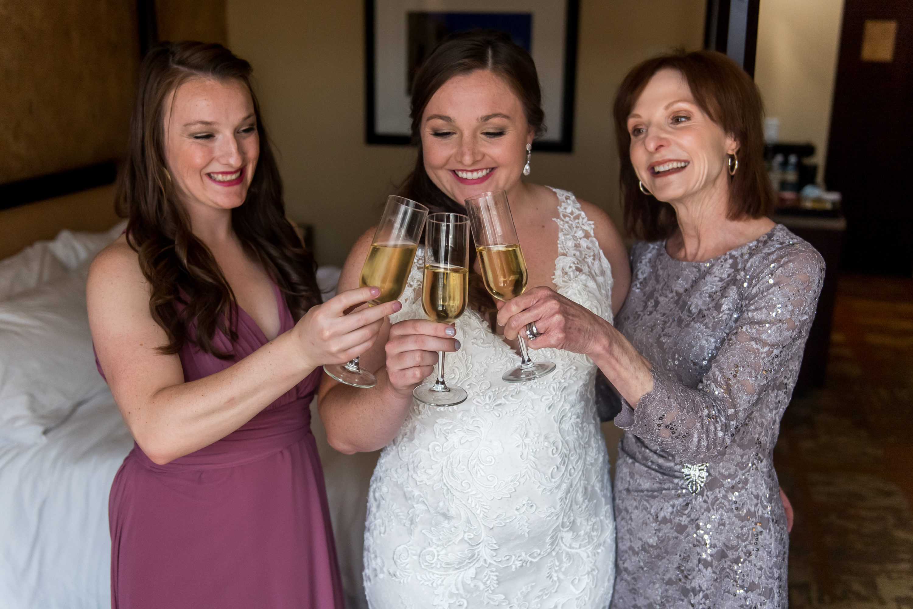 The bride, maid of honor and mother toast in their hotel room during a Greenbriar Inn wedding in Boulder, Colorado.