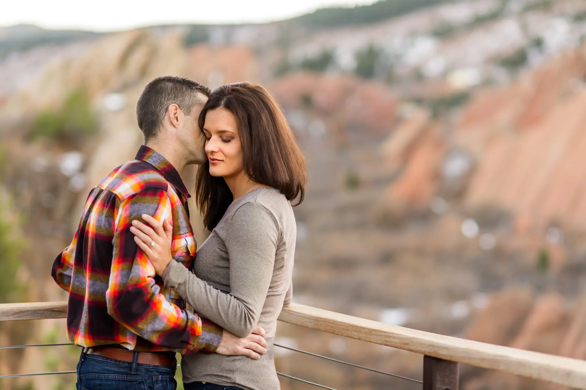 Victoria and Justin embrace in Roxborough State Park Littleton for their engagement session.