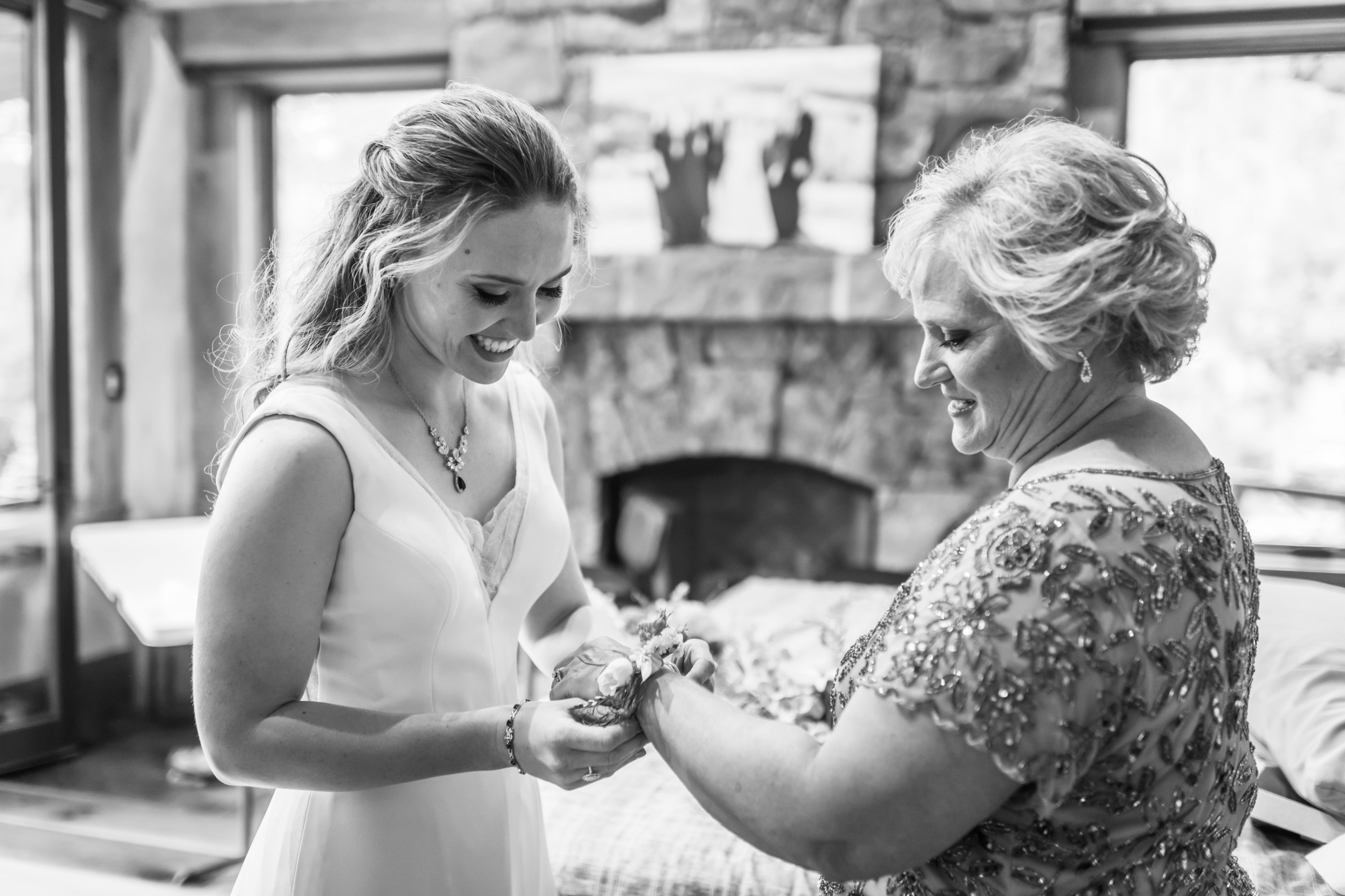 The bride puts on the corsage for her mother before her Telluride, Colorado, wedding.