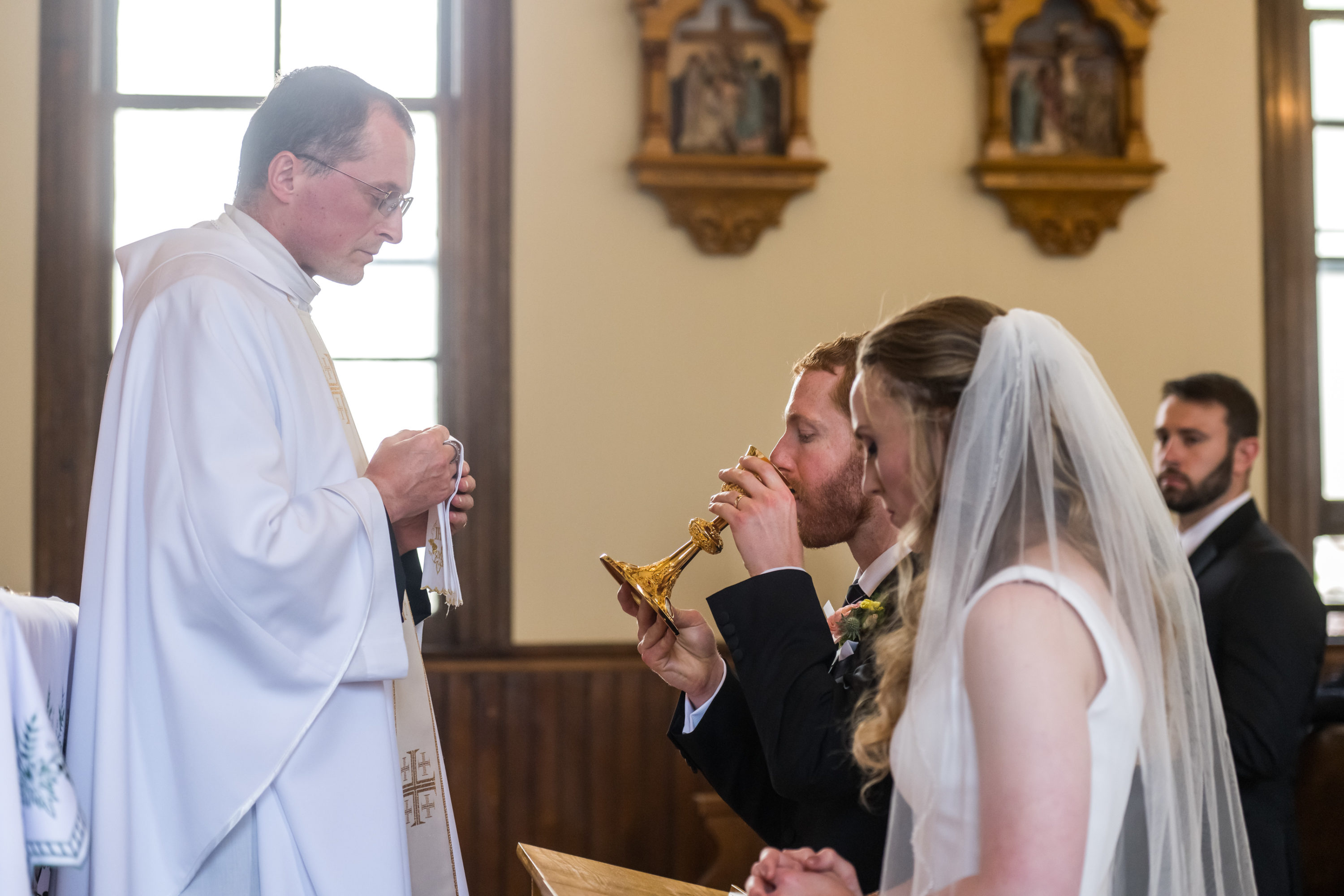 The groom sips consecrated wine during his wedding at St. Patrick's Church Telluride.