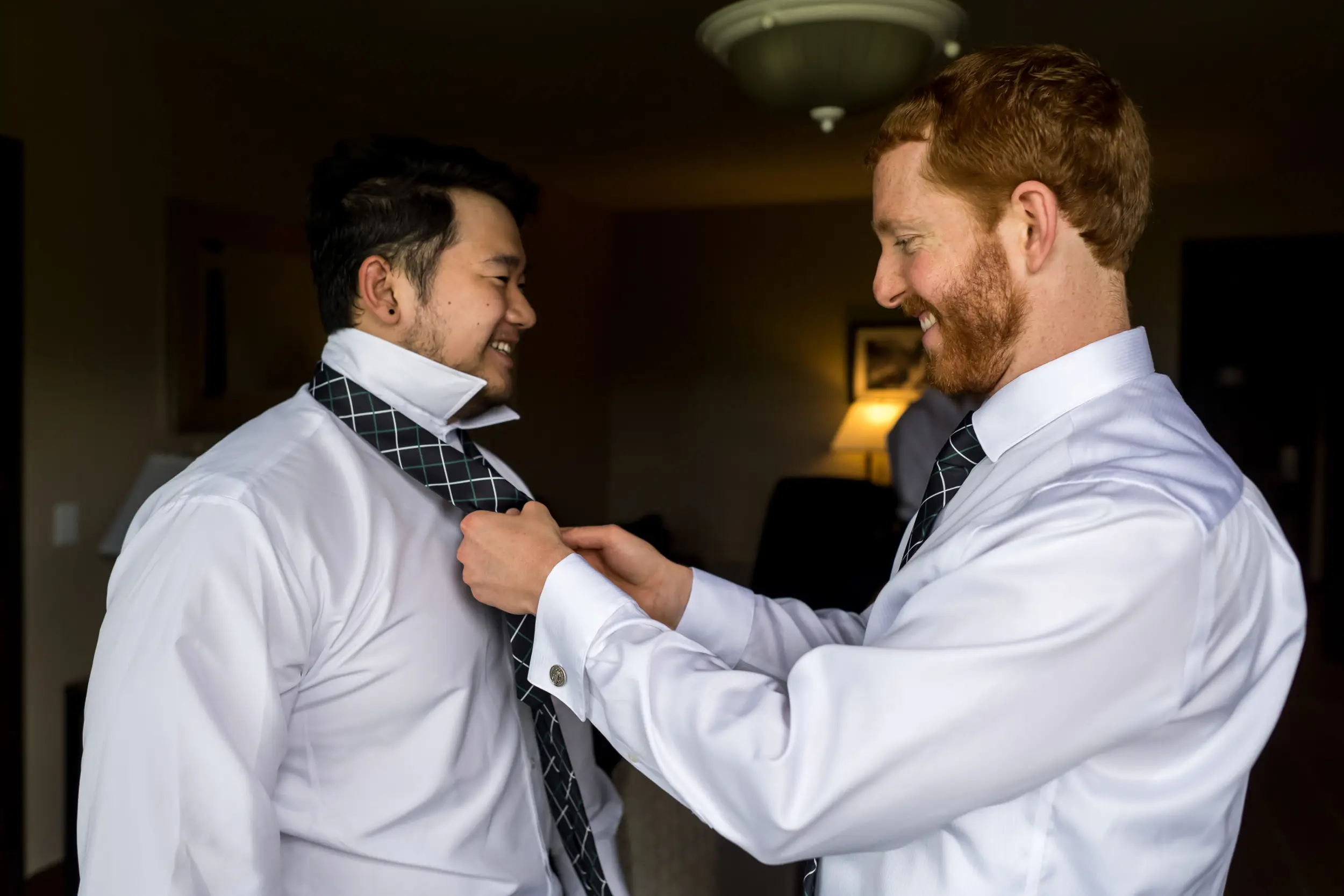 The groom adjusts the tie of a groomsman before his Telluride, Colorado, wedding.