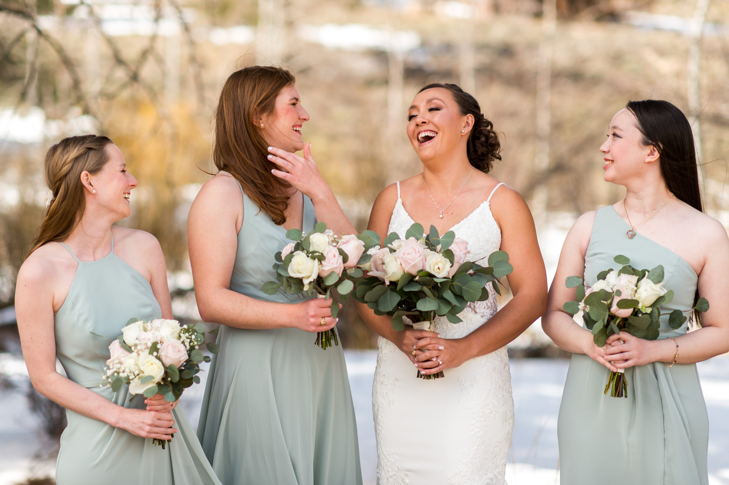 The bride and bridesmaids laugh during the bride's YMCA of the Rockies wedding in Estes Park, Colorado.