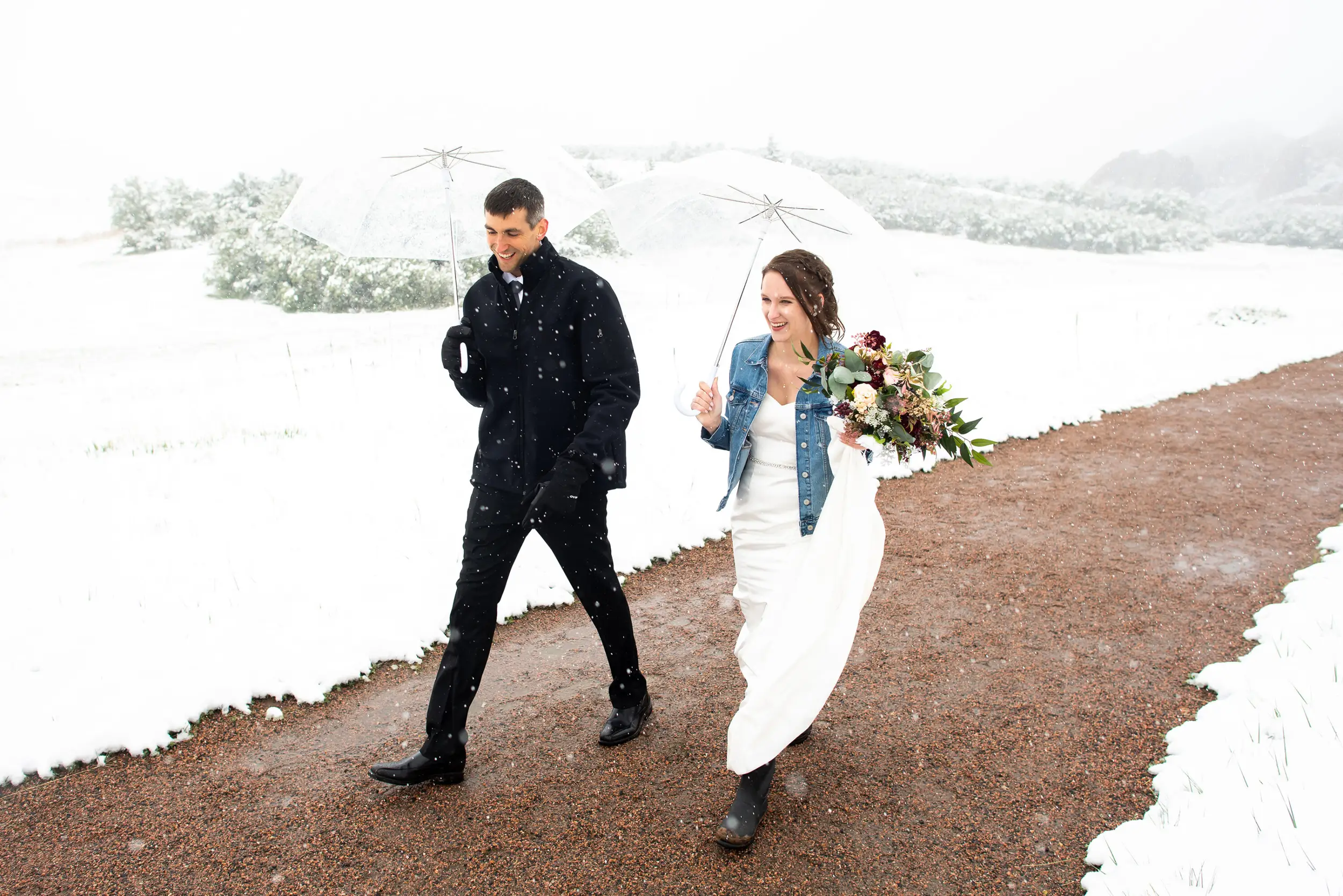 Elizabeth and Andrew walk toward their Roxborough State Park Wedding in the snow.