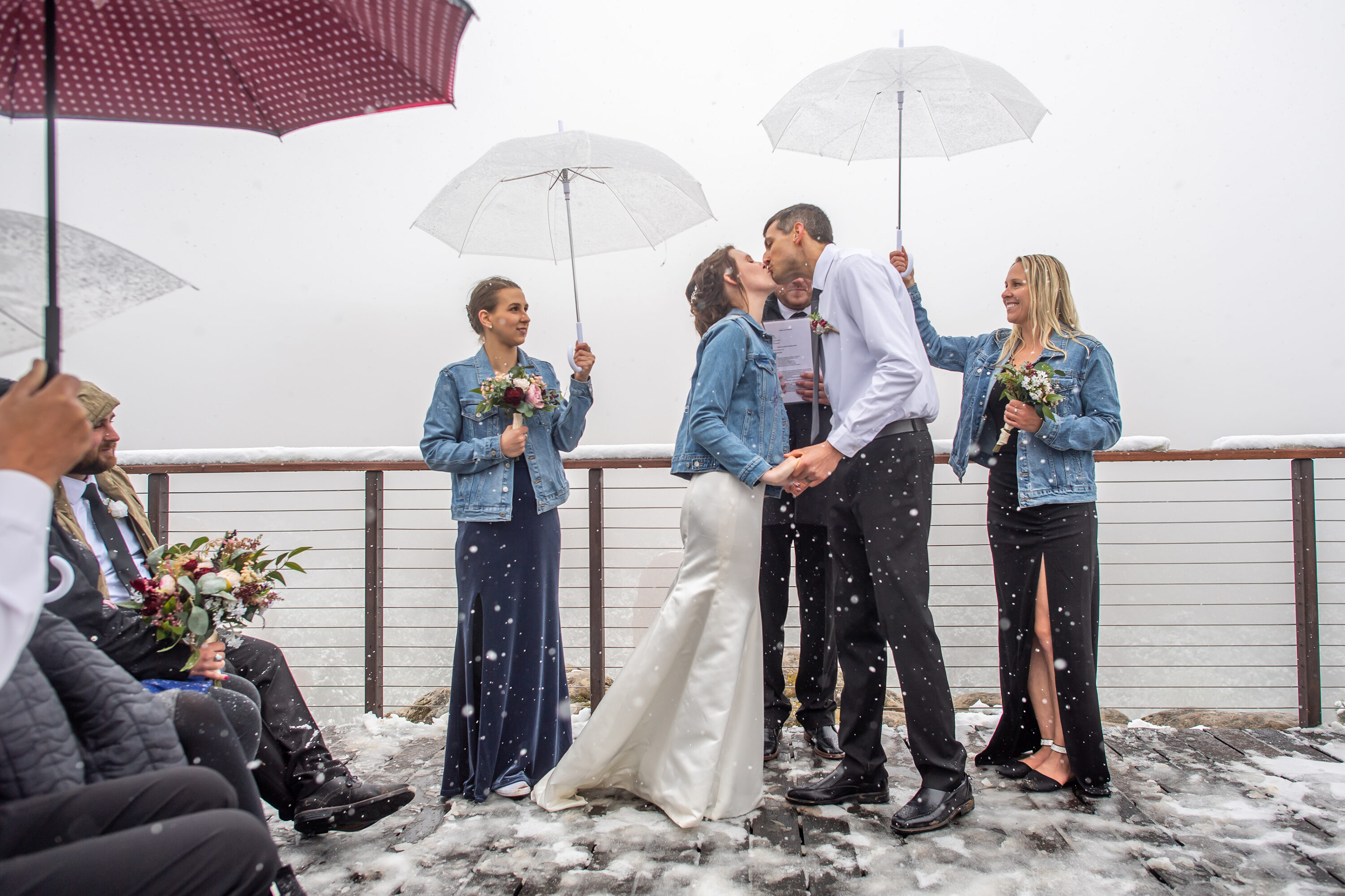 Liz and Andrew kiss during their Roxborough State Park wedding at Lyons Overlook in the snow.