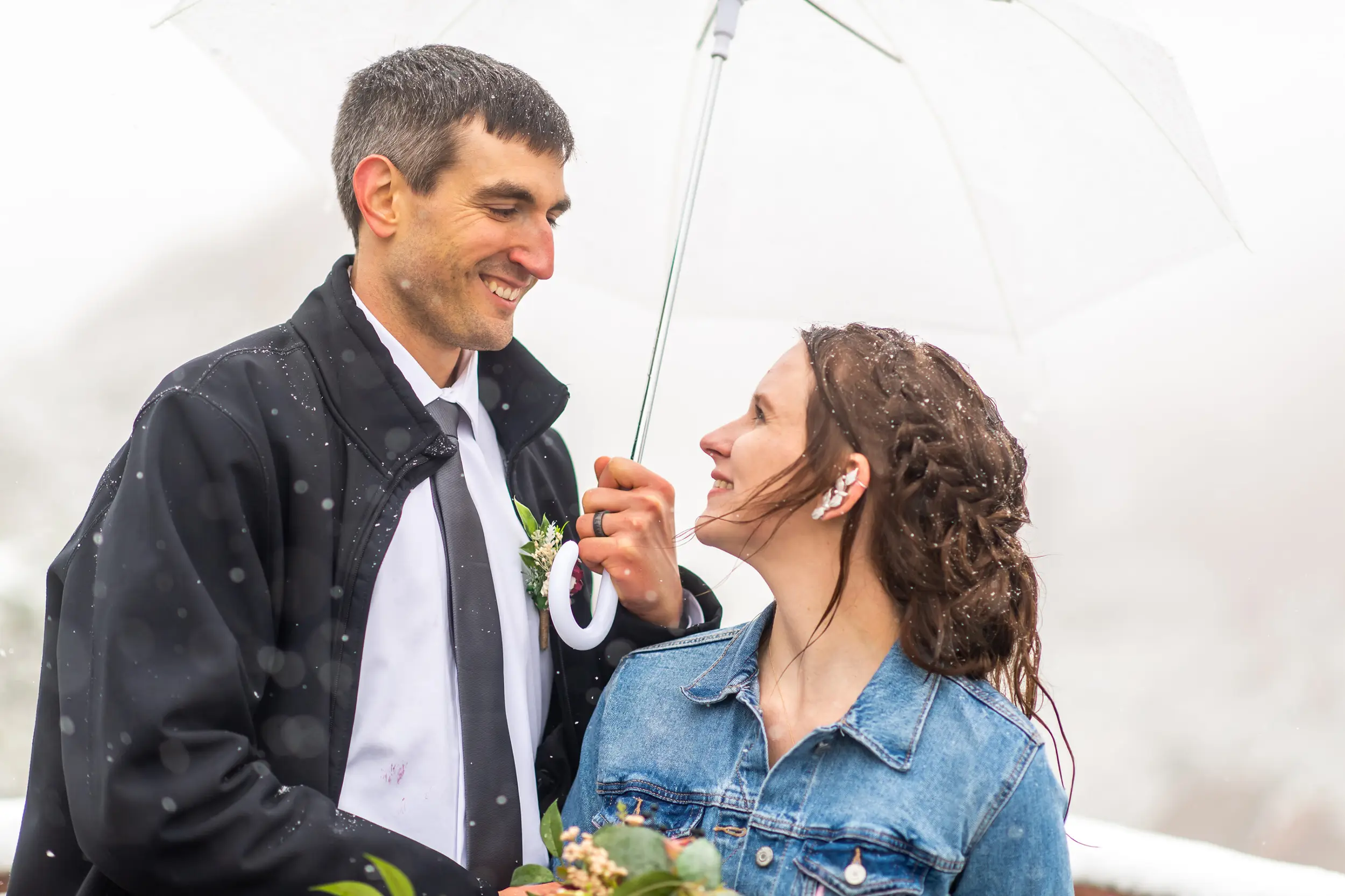 Andrew and Liz look to each other during their Roxborough State Park wedding at Lyons Overlook in the snow.