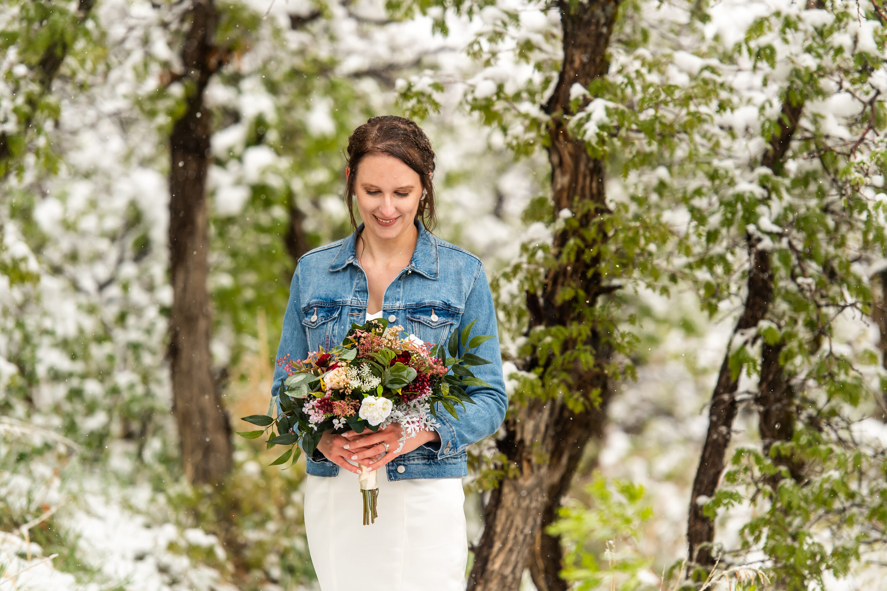 Liz poses after her Roxborough State Park wedding at Lyons Overlook in the snow.