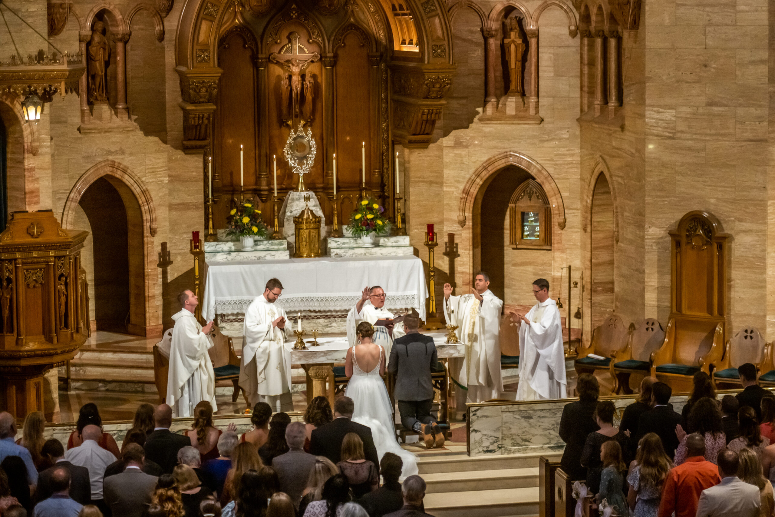 A bride and groom kneel before an altar during a Holy Ghost Church Denver wedding in Denver, Colorado.