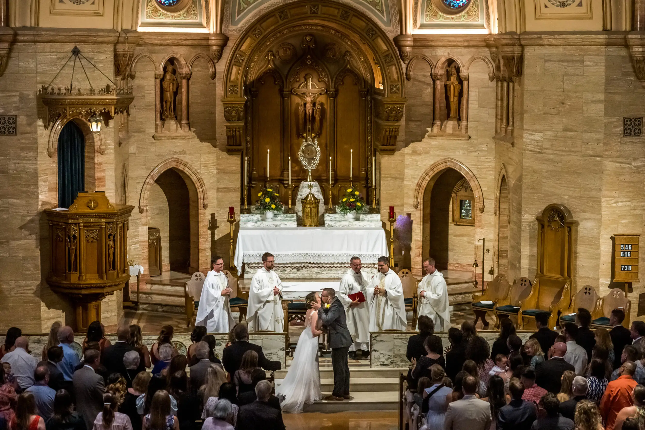 The bride and groom kiss after their wedding Mass at Holy Ghost Catholic Church in Denver, Colorado.