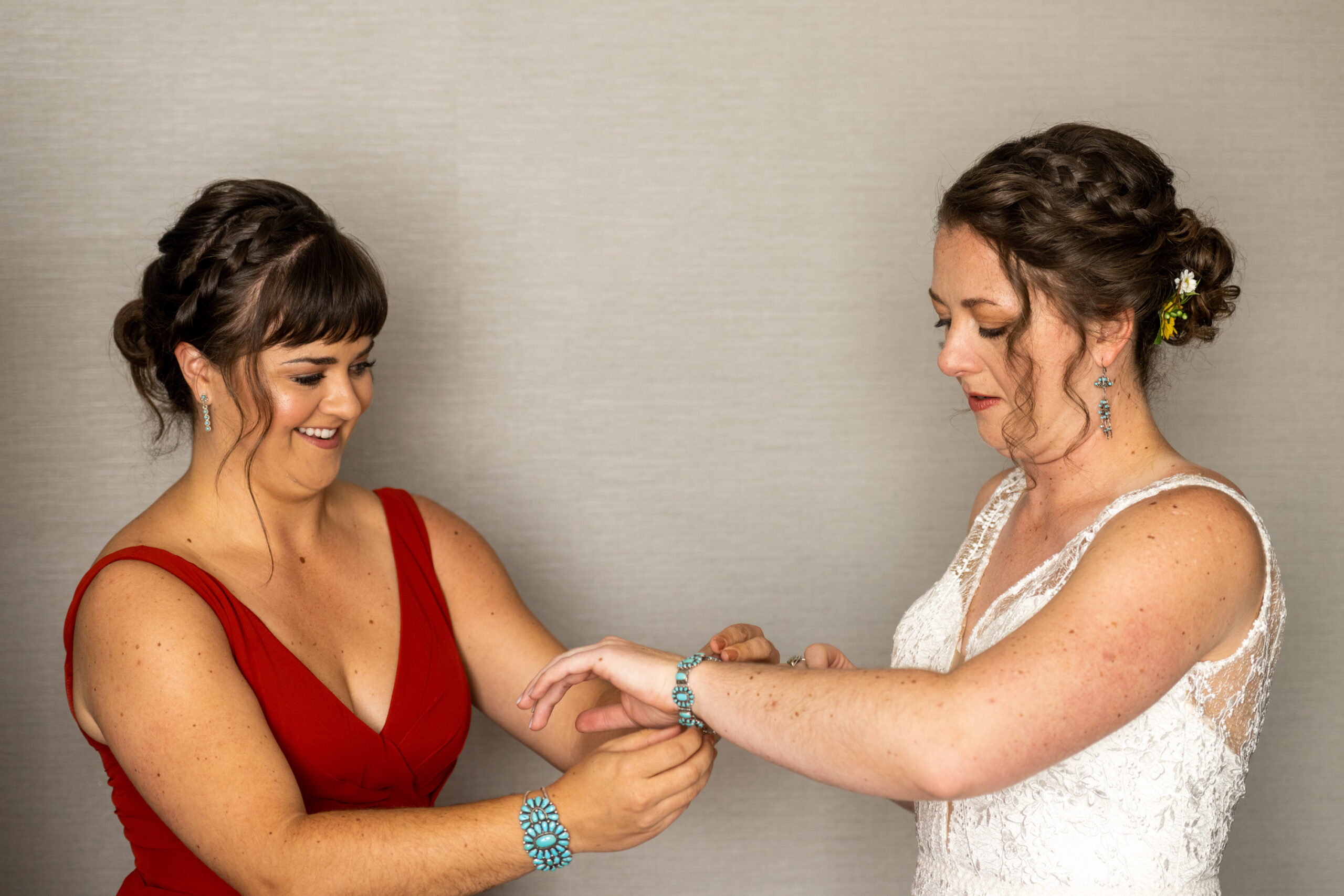 A bridesmaid puts a bracelet on the bride before a Holy Ghost Church wedding in Denver, Colorado.
