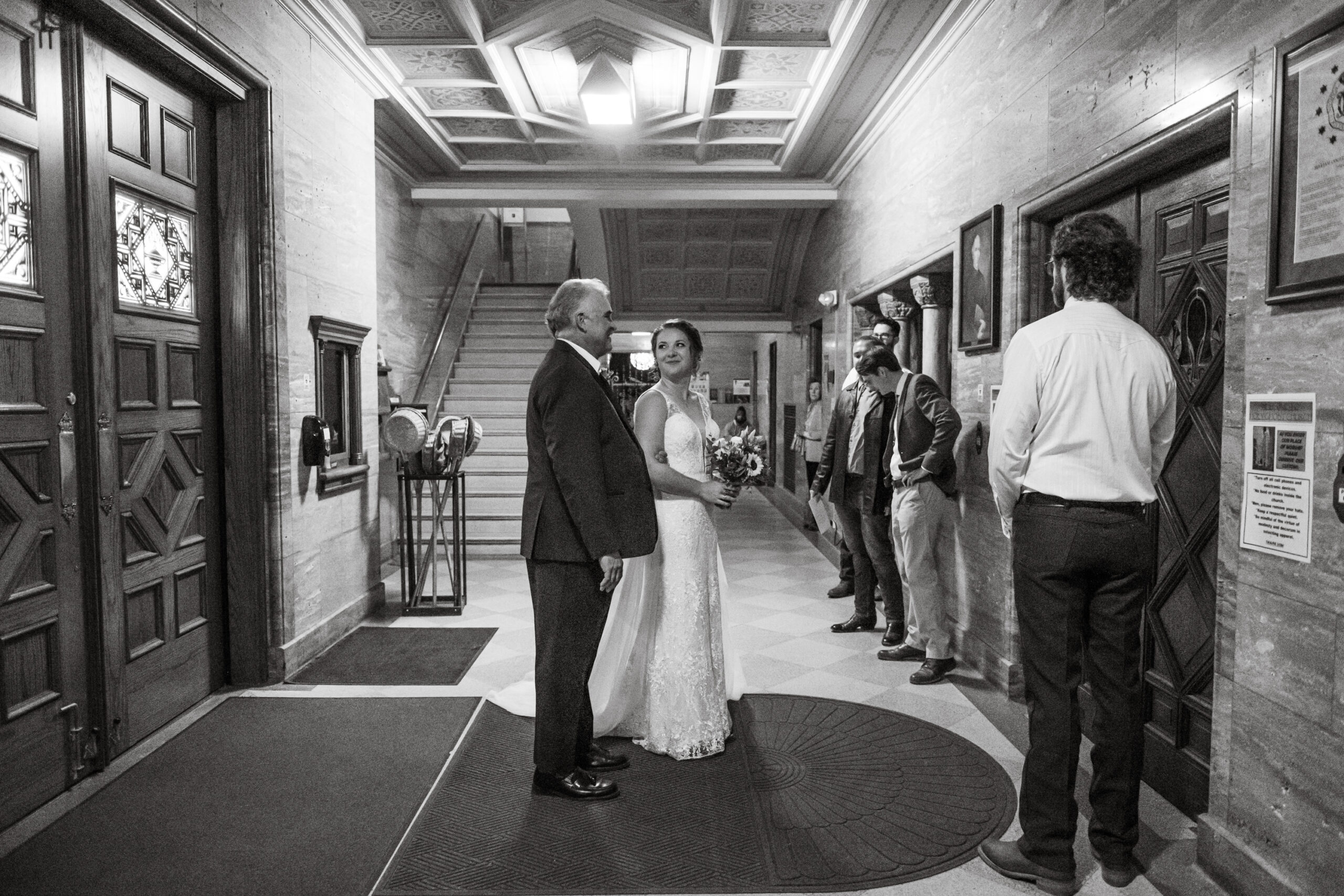 A bride stands with her father before entering Holy Ghost Catholic Church in Denver, Colorado, to be married.
