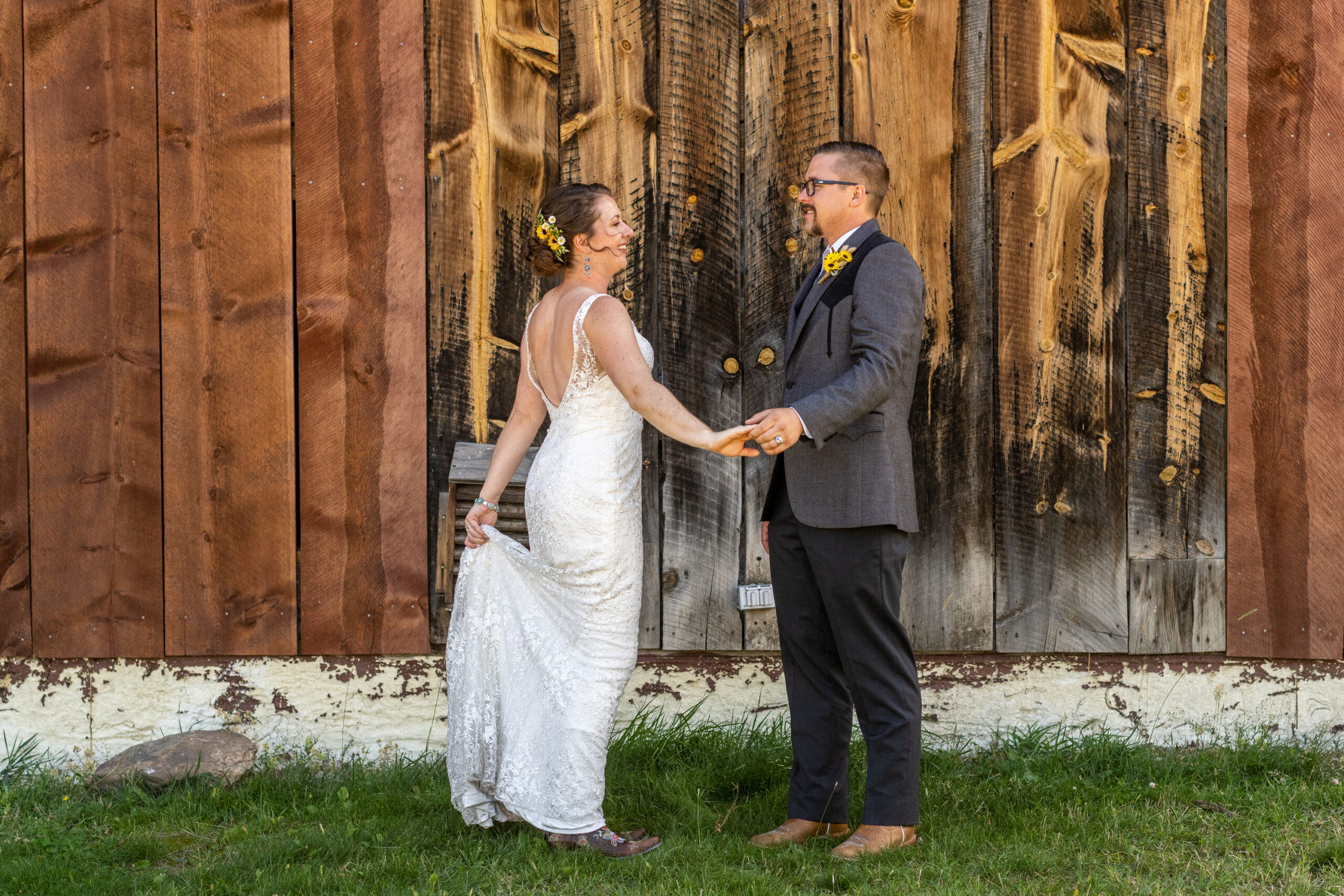 A bride and groom look into each other's eyes next to a barn at Three Sisters Park in Evergreen, Colorado.