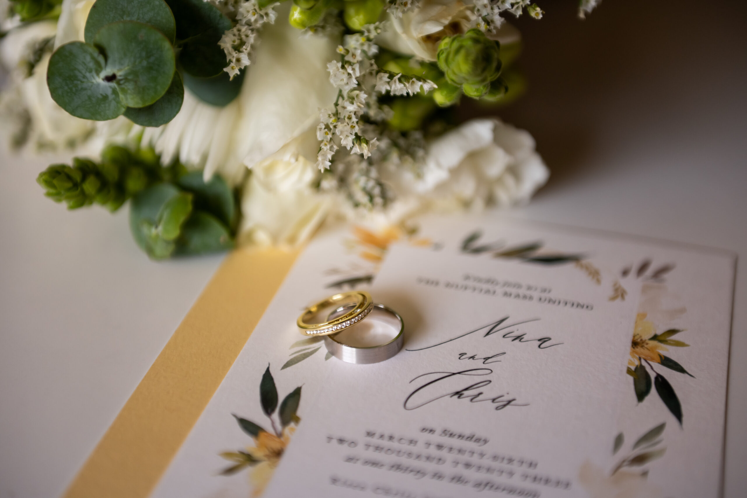 A lay flat of the rings and invitation during a Risen Christ Church Denver wedding in Denver, Colorado.